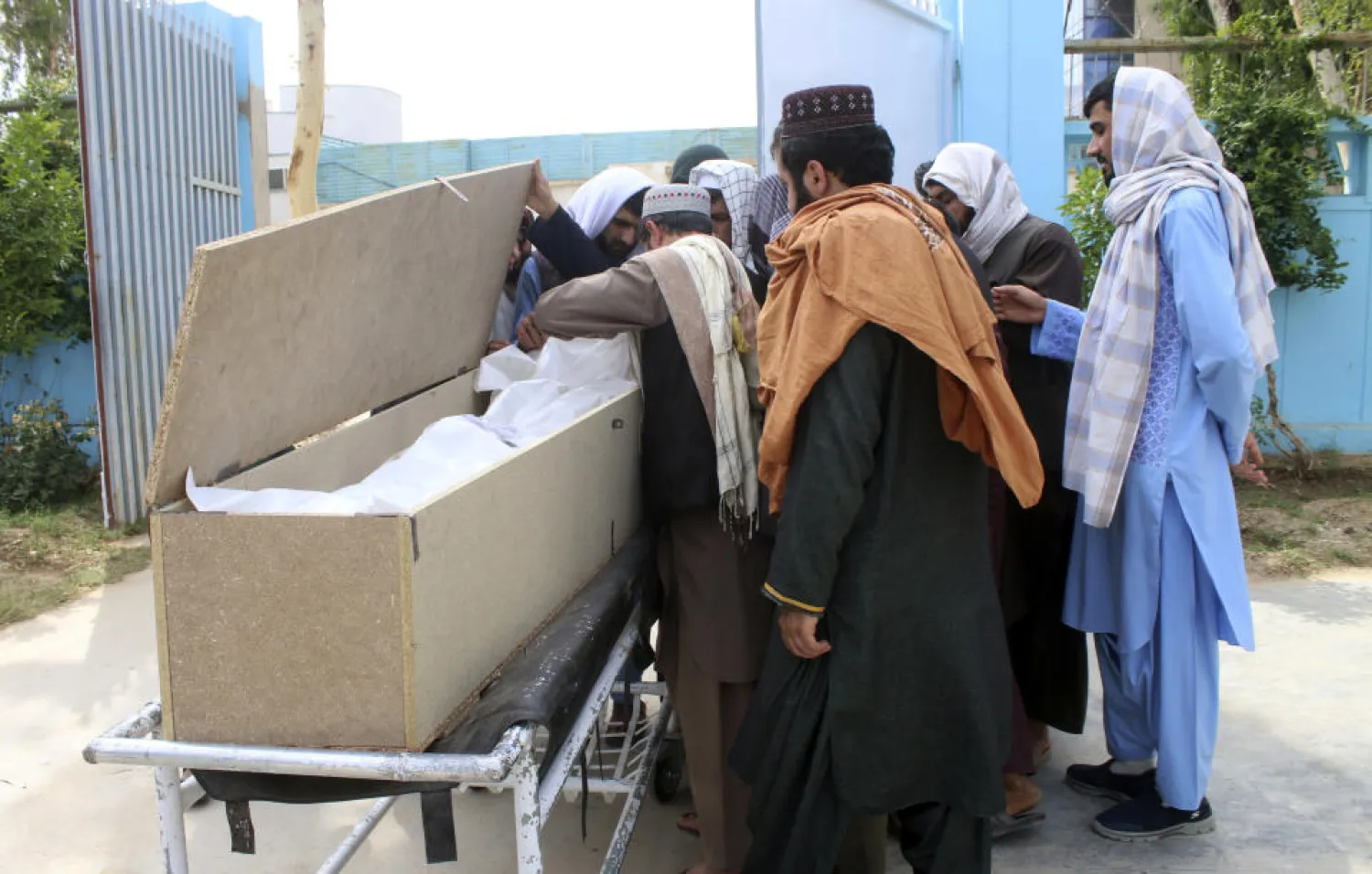 Afghans mourn over the body of Nimat Rawan, a former Afghan TV presenter, at a hospital in Kandahar, Afghanistan, Tuesday, May 6, 2021. (AP Photo/Sidiqullah Khan)