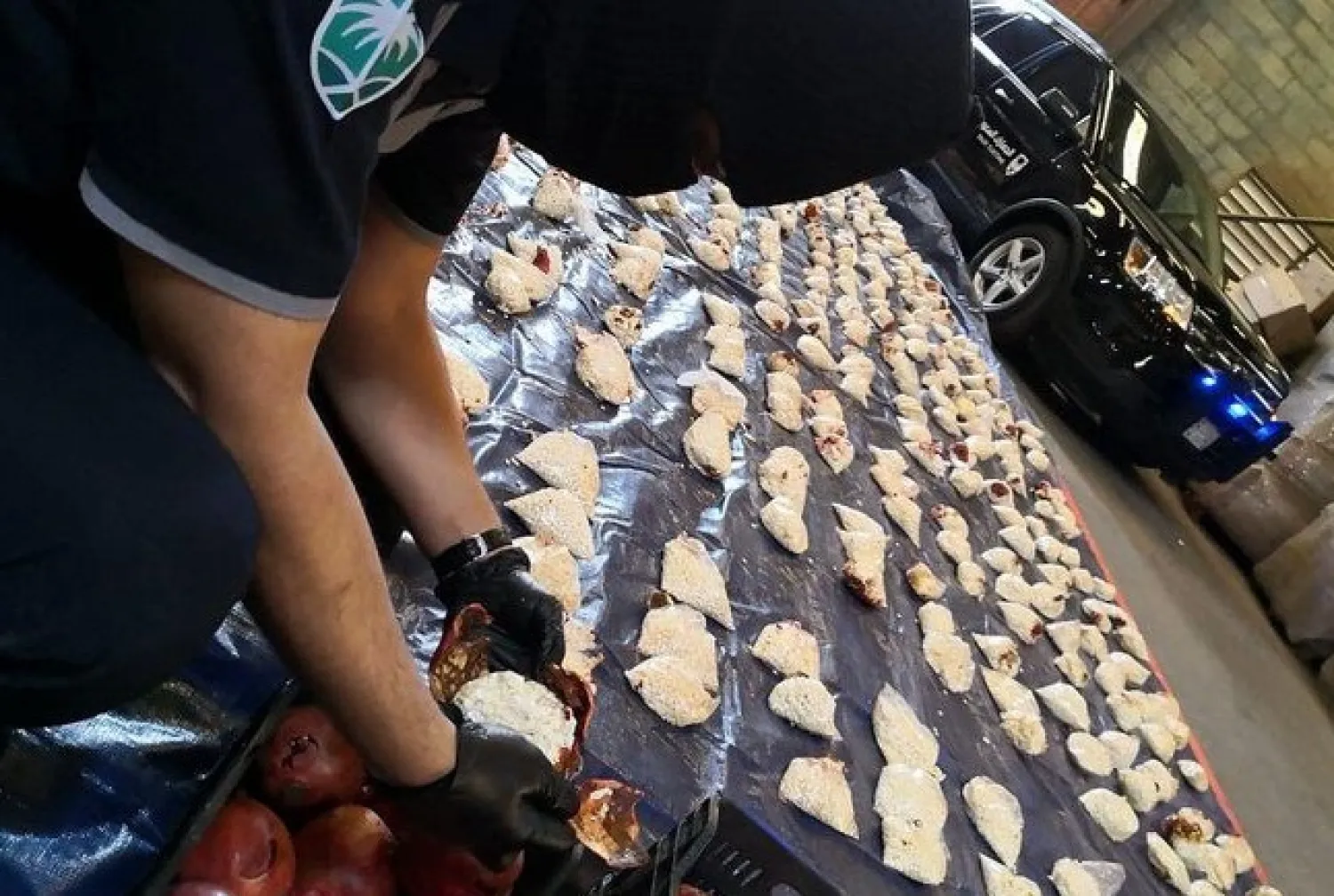 A Saudi Custom officer opens imported pomegranates, as customs foiled a attempt to smuggle millions of Captagon pills, which came from Lebanon. (SPA)
