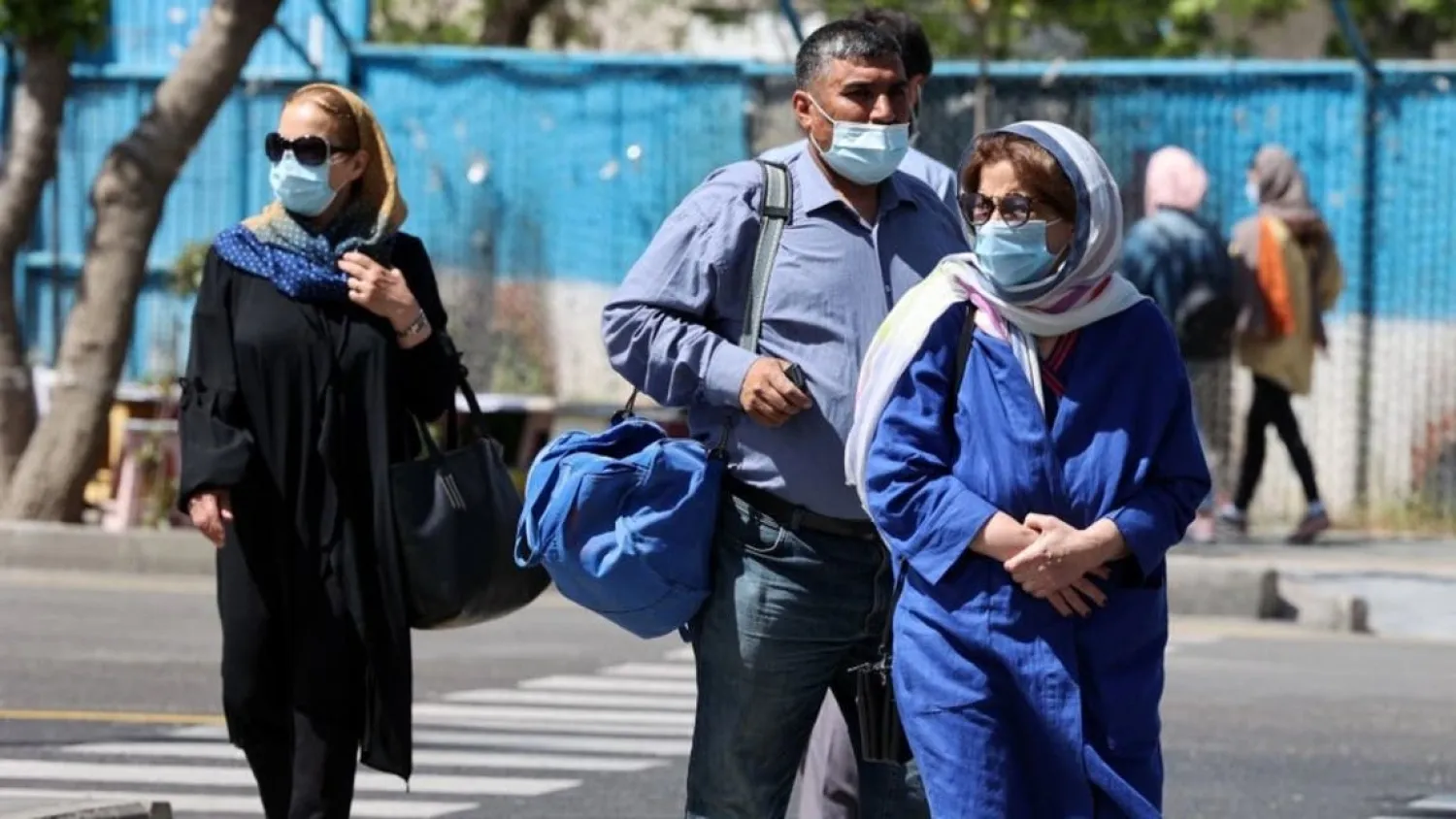 Iranians wearing potective masks go about their day in the capital Tehran, on April 12, 2021. (AFP)
