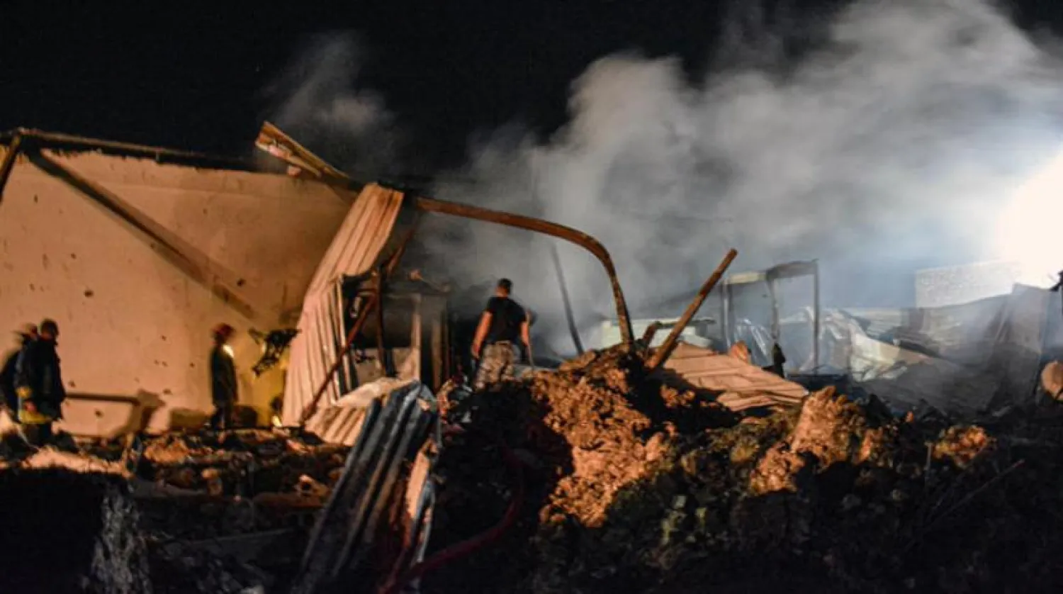 Syrians at a site in Latakia that targeted by Israeli raids (AFP)
