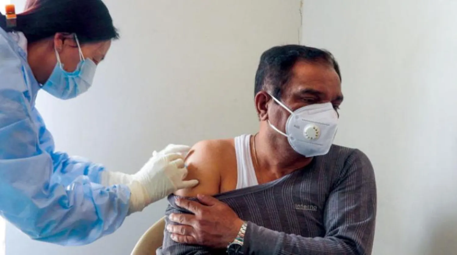 Dün Ladakh’da Hintli bir kişiyi Kovid-19’a karşı aşılayan bir sağlık çalışanı (AFP)