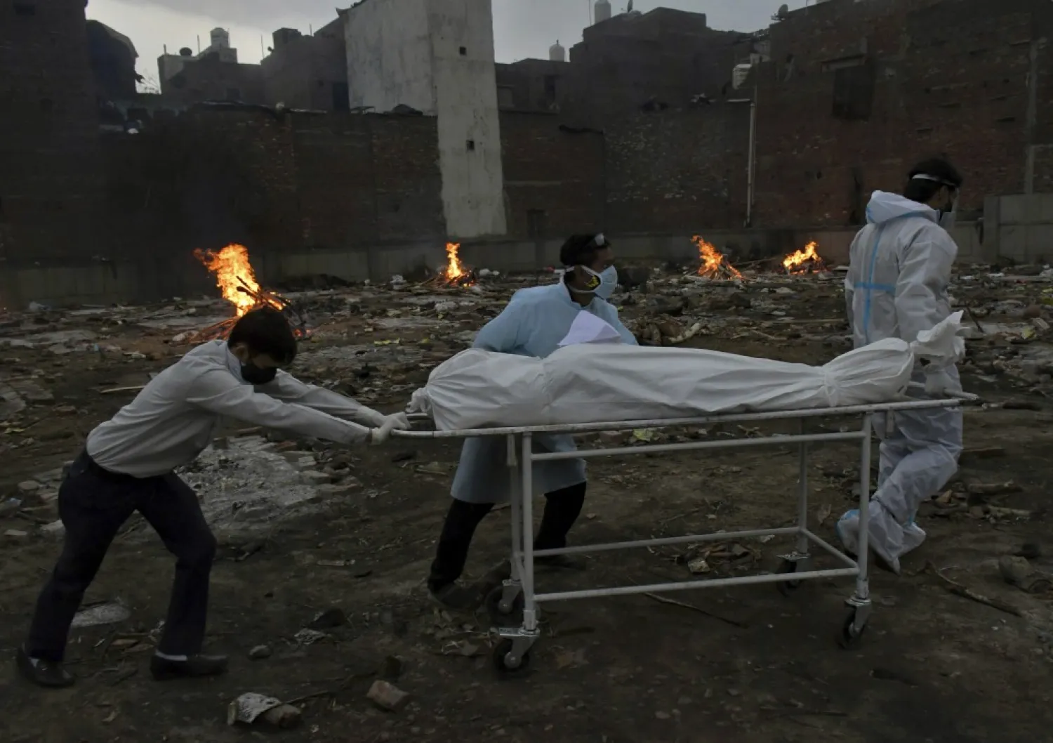 Body of a COVID-19 victim is wheeled in for cremation in a ground that has been converted into a crematorium in New Delhi, India, Thursday, May 6, 2021. (AP Photo/Ishant Chauhan)