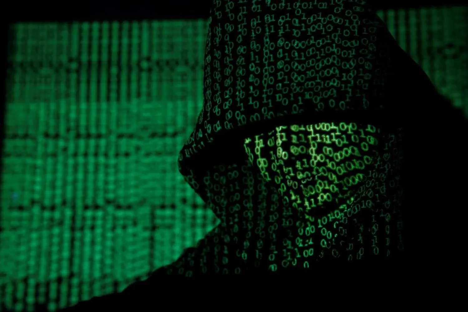 A projection of cyber code on a hooded man is pictured in this illustration picture taken on May 13, 2017. (Reuters)