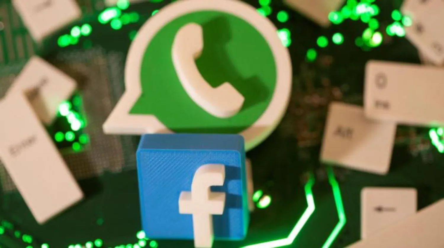 3D printed Facebook and WhatsApp logos and keyboard buttons are placed on a computer motherboard in this illustration taken January 21, 2021. Reuters