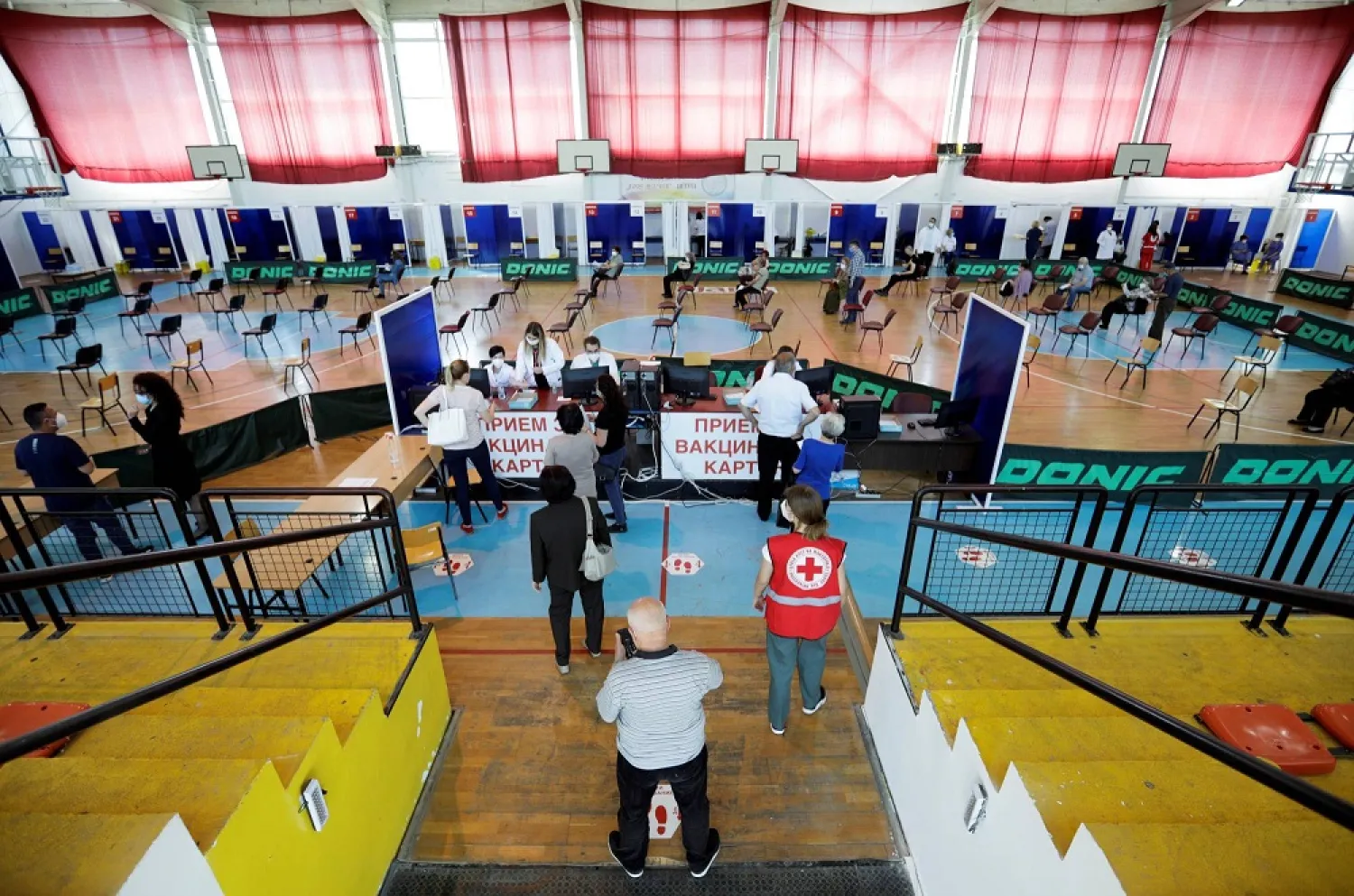 People arrive to receive a dose of China's Sinopharm COVID-19 vaccine at a sports center in Stip, North Macedonia. (Reuters)
