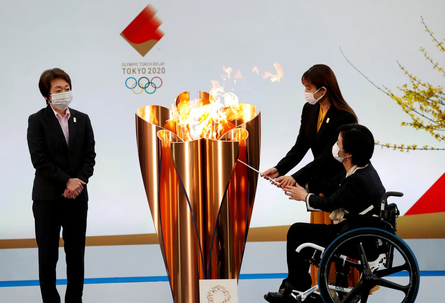 Tokyo 2020 President Seiko Hashimoto looks on as actor Satomi Ishihara and Paralympian Aki Taguchi light the celebration cauldron. Reuters