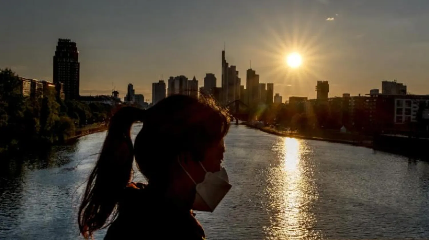 Almanya, Frankfurt'ta bir köprüden geçen maskeli bir kadın (AP)