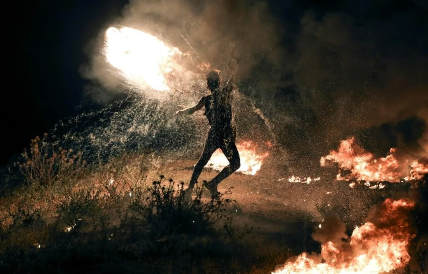 A Palestinian protester burns tires along the Israel-Gaza border following fierce clashes in Israeli-annexed east Jerusalem between Palestinians and Israeli police | AFP