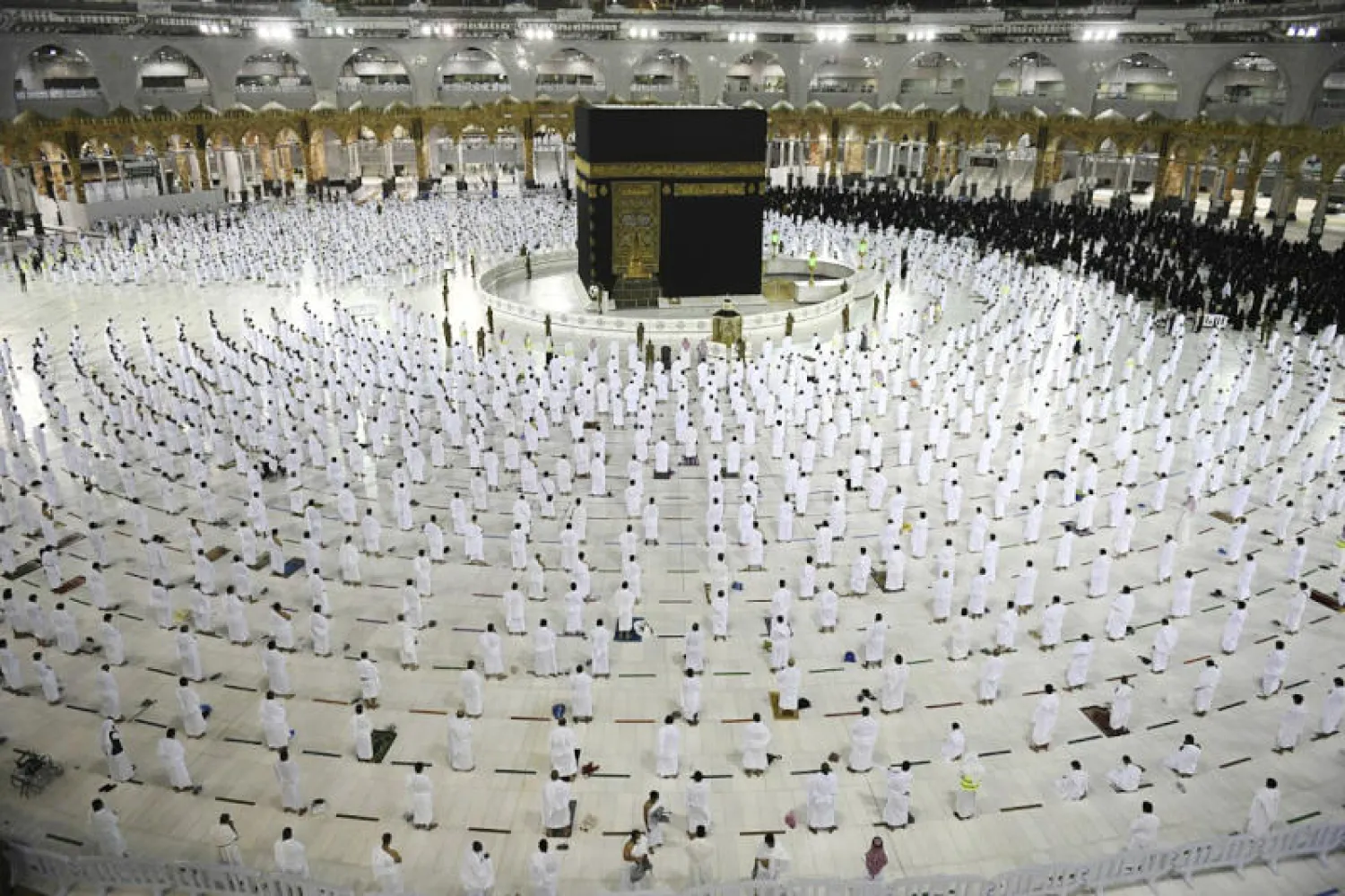 مصلون ومعتمرون يؤدون الصلاة في صحن المطاف وسط التزام بتطبيق الإجراءات الوقائية (أ.ب)