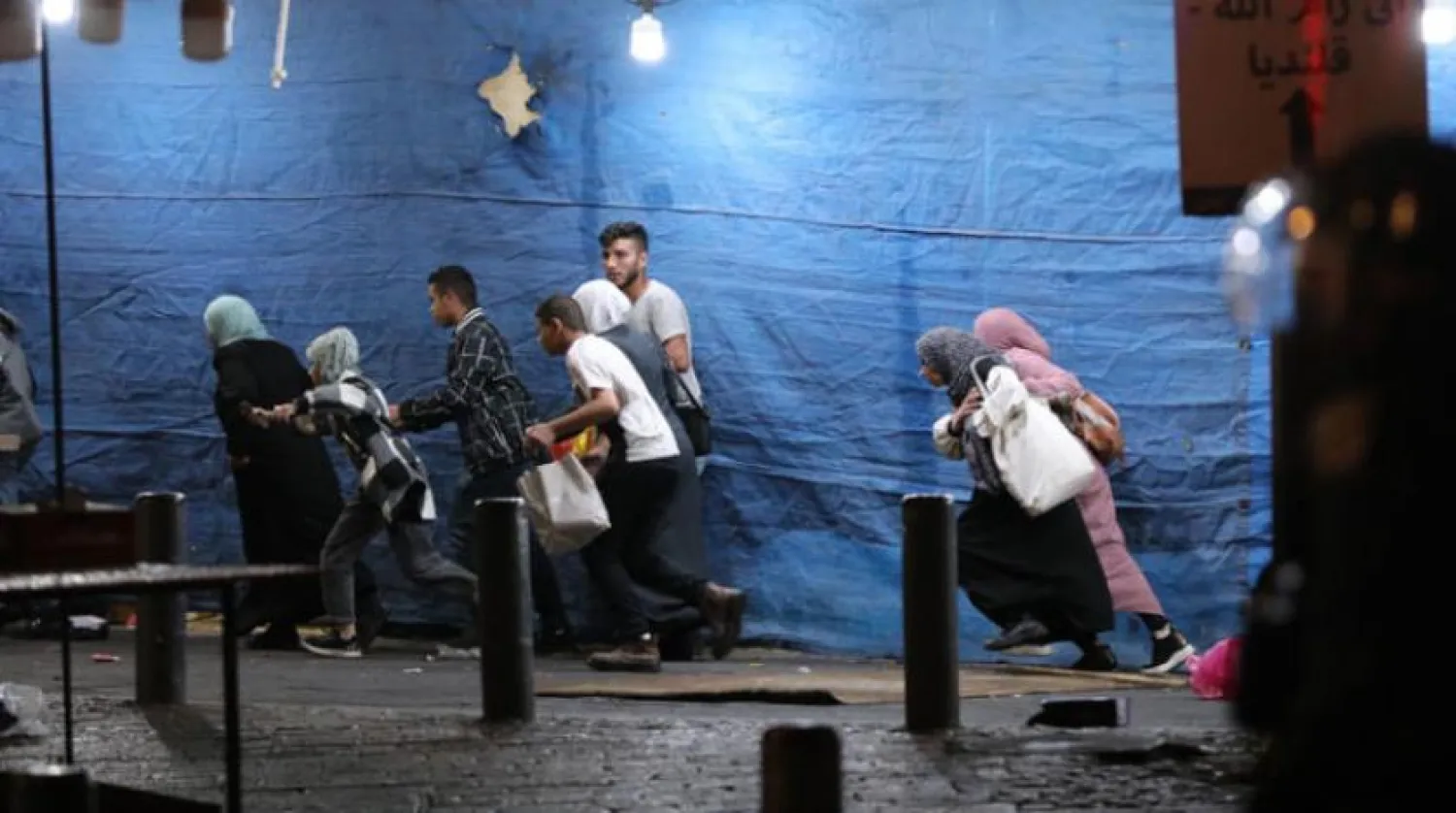 Filistinliler, dün gece Kudüs’ün Şeyh Cerrah mahallesindeki çatışmalarda İsrail polisinden kaçmaya çalışıyor (EPA)