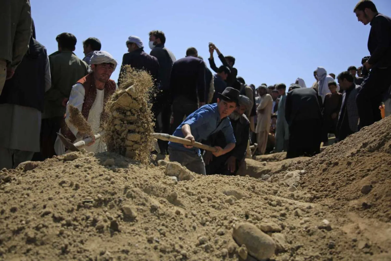 Afghan men bury a victim of deadly bombings on Saturday near a school, at a cemetery west of Kabul, Afghanistan, Sunday, May 9, 2021. (AP Photo/Mariam Zuhaib)