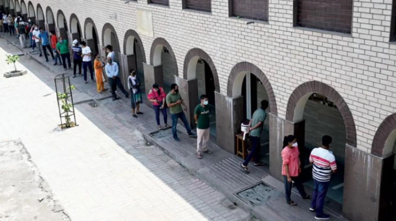 Yeni Delhi’de koronavirüse karşı aşı olmak için sıraya giren insanlar (AFP)