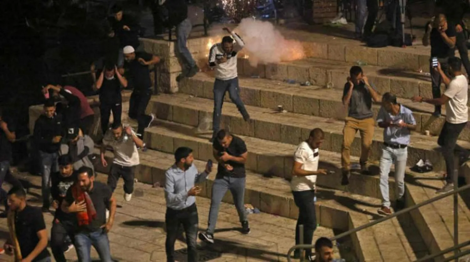 Palestinian protesters flee Israeli army bombs in East Jerusalem on Saturday evening (AFP) 
