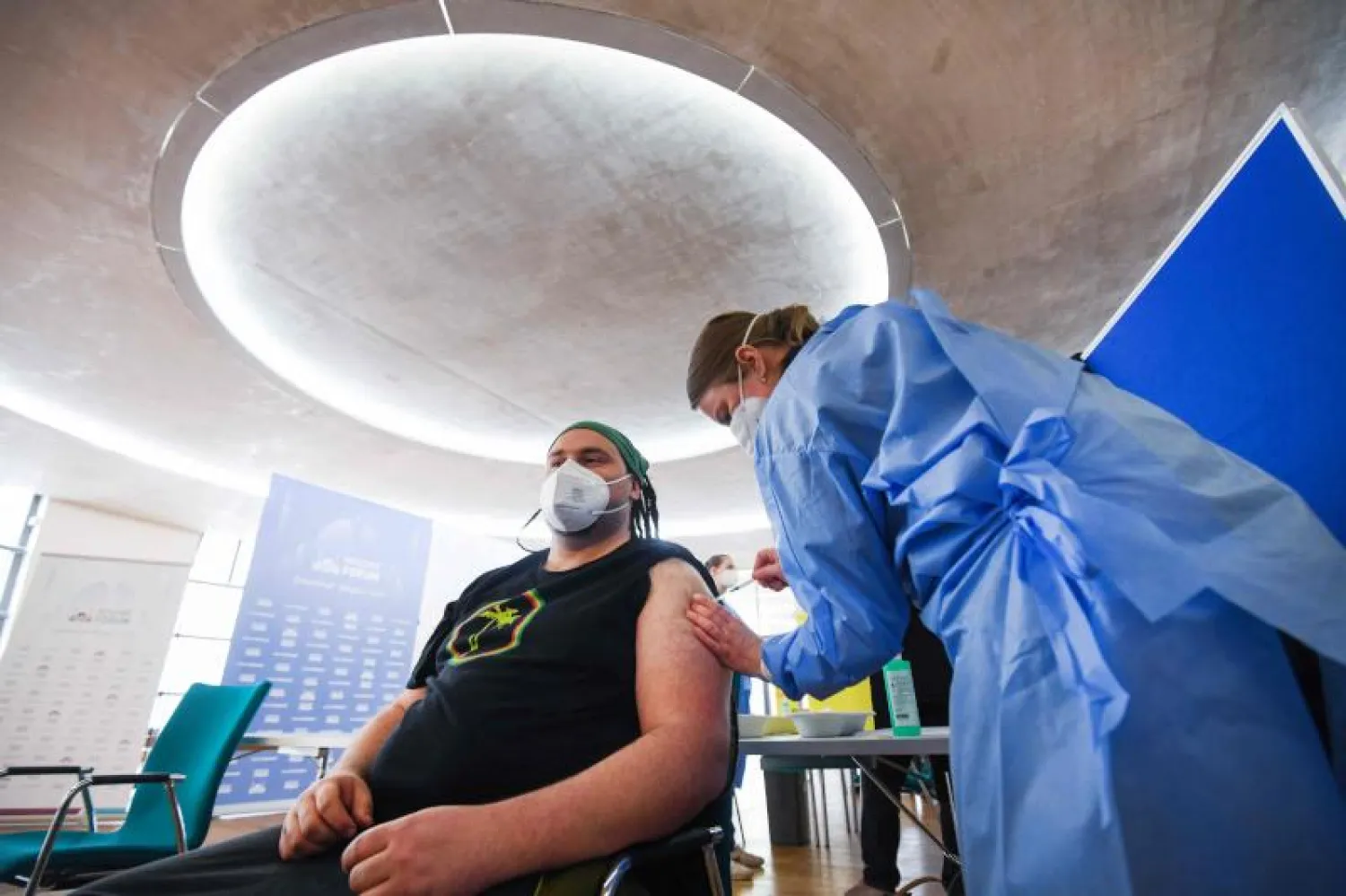 رجل يحصل على تطعيم ضد «كورونا» في المسجد المركزي في كولونيا (أ.ف.ب)