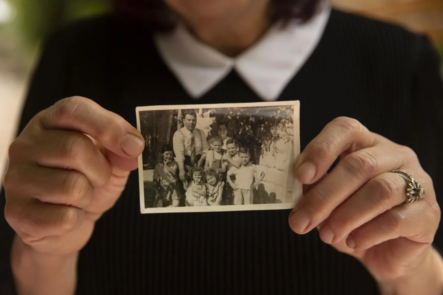 Samira Dajani holds a photo of her family in 1956 after they moved into their home in the Sheikh Jarrah neighborhood of east Jerusalem, Sunday, May 9, 2021. (AP)