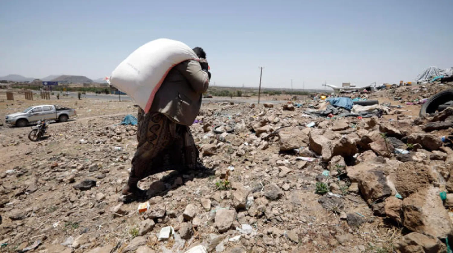 نازح يحمل مساعدات غذائية على أطراف صنعاء (إ.ب.أ)