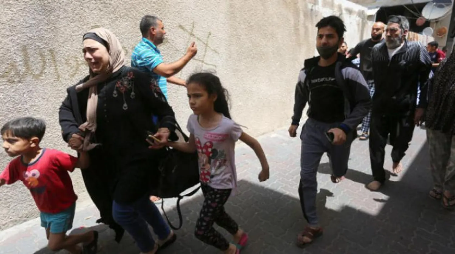 İsrail’in Hamas’ın füzelerine misilleme olarak bir binanın hedef alınmasının ardından Gazzeliler tahliye edilirken (DPA)