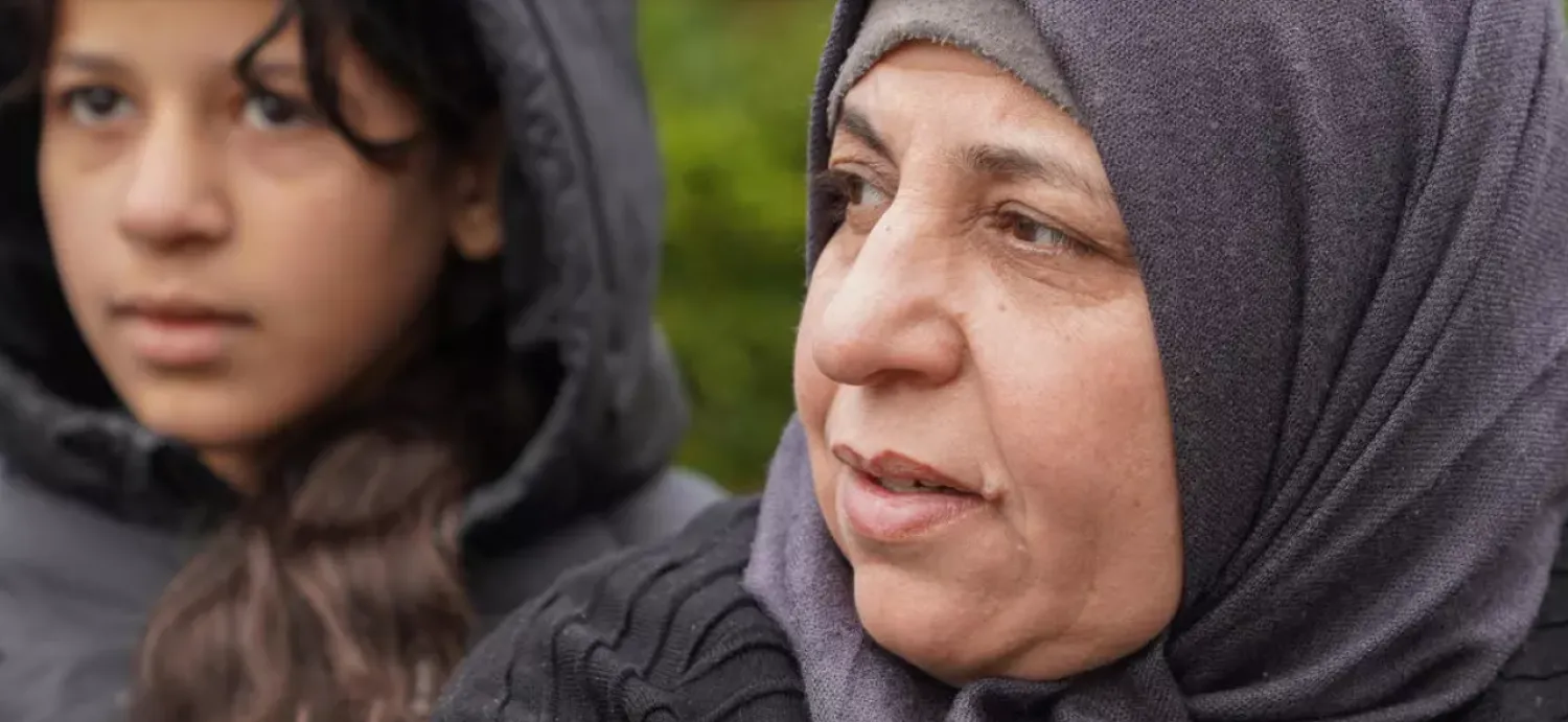Sabriya al-Fayyad (R), a Syrian living in Denmark whose residency papers were withdrawn by the authorities in late March, sits outside a public park with her daughter in Vejle, Denmark, on May 5 2021. (Photo by Tom LITTLE / AFP)