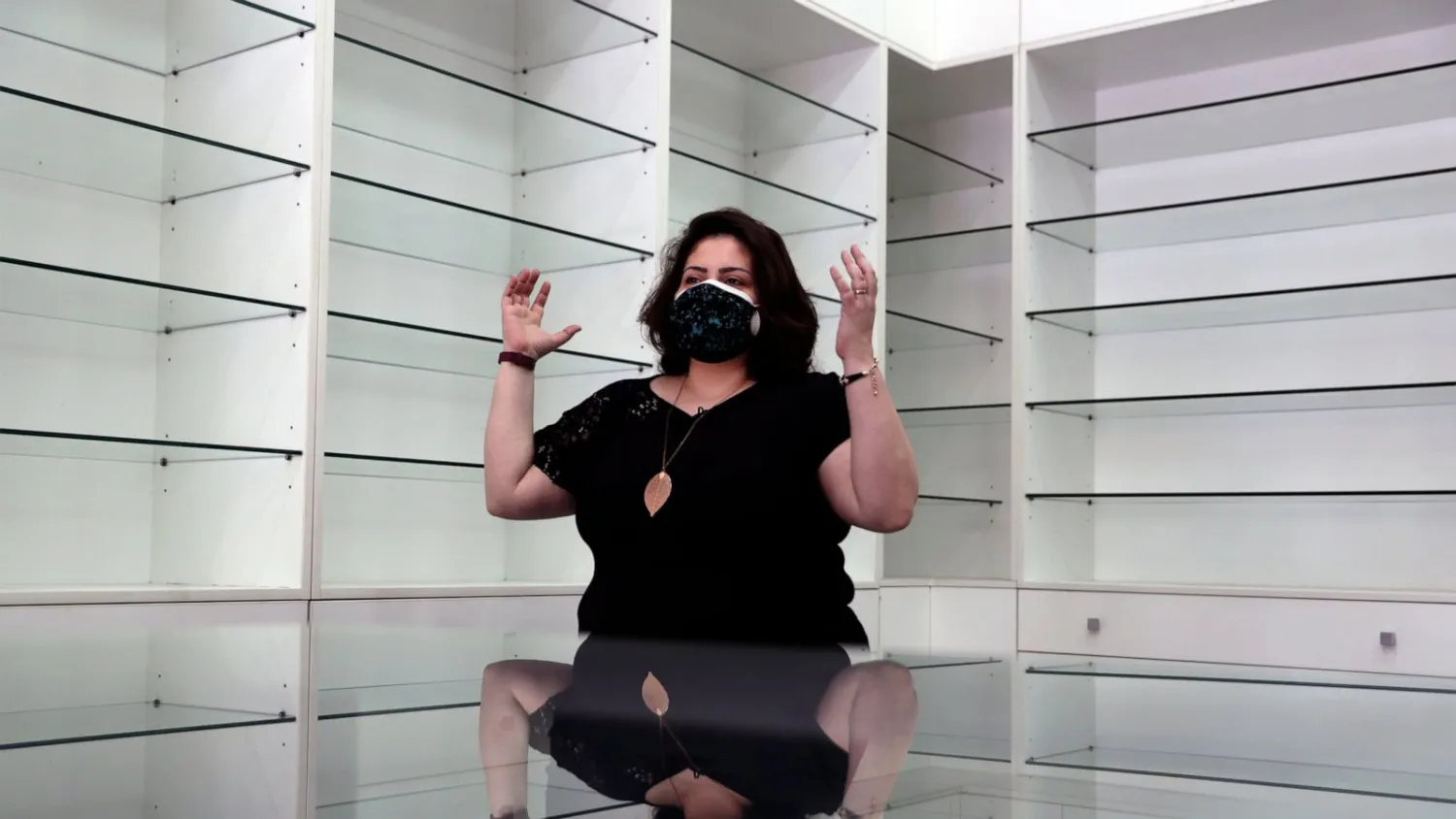 Pharmacist Rita El Khoury speaks in the middle of her empty pharmacy after selling her stock in preparation for her move to France with her husband, in Ballouneh, north of Beirut, Lebanon, Wednesday, April 21, 2021. (AP Photo/Bilal Hussein)