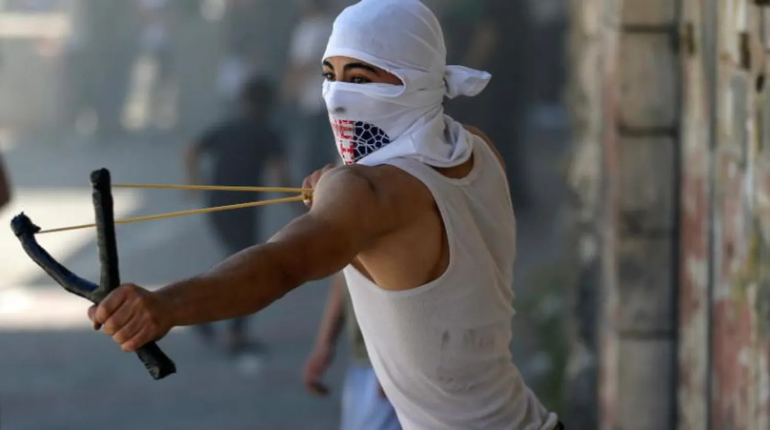 Kudüs’te İsrail askerlerine taş atan bir Filistinli (Reuters)