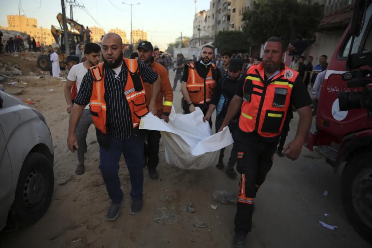 Palestinians carry the body of a child found in the rubble of a house belonging to the Al-Tanani family, that was destroyed in Israeli airstrikes in town of Beit Lahiya, northern Gaza Strip, Thursday, May 13, 2021. (AP Photo/Abdel Kareem Hana)
