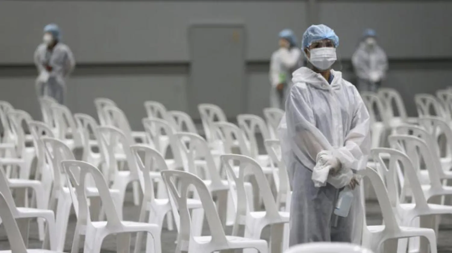 Bangkok’ta bir aşı merkezini sterilize etmeye hazırlanan işçiler (EPA)