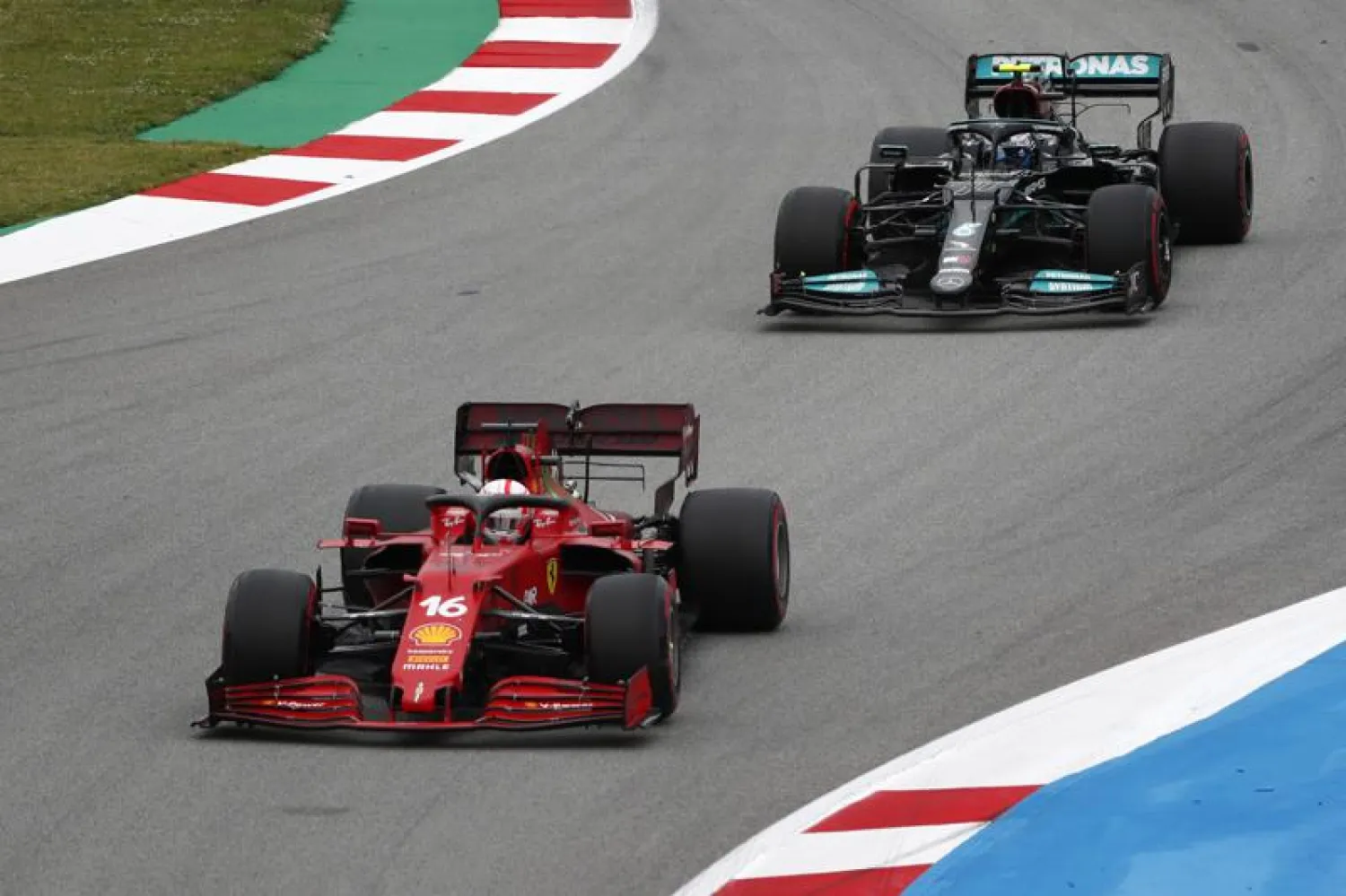 Ferrari driver Charles Leclerc takes a curve followed by Mercedes driver Valtteri Bottas during the F1 Grand Prix at the Barcelona Catalunya racetrack in Montmelo, Spain, Sunday, May 9, 2021. (AP)