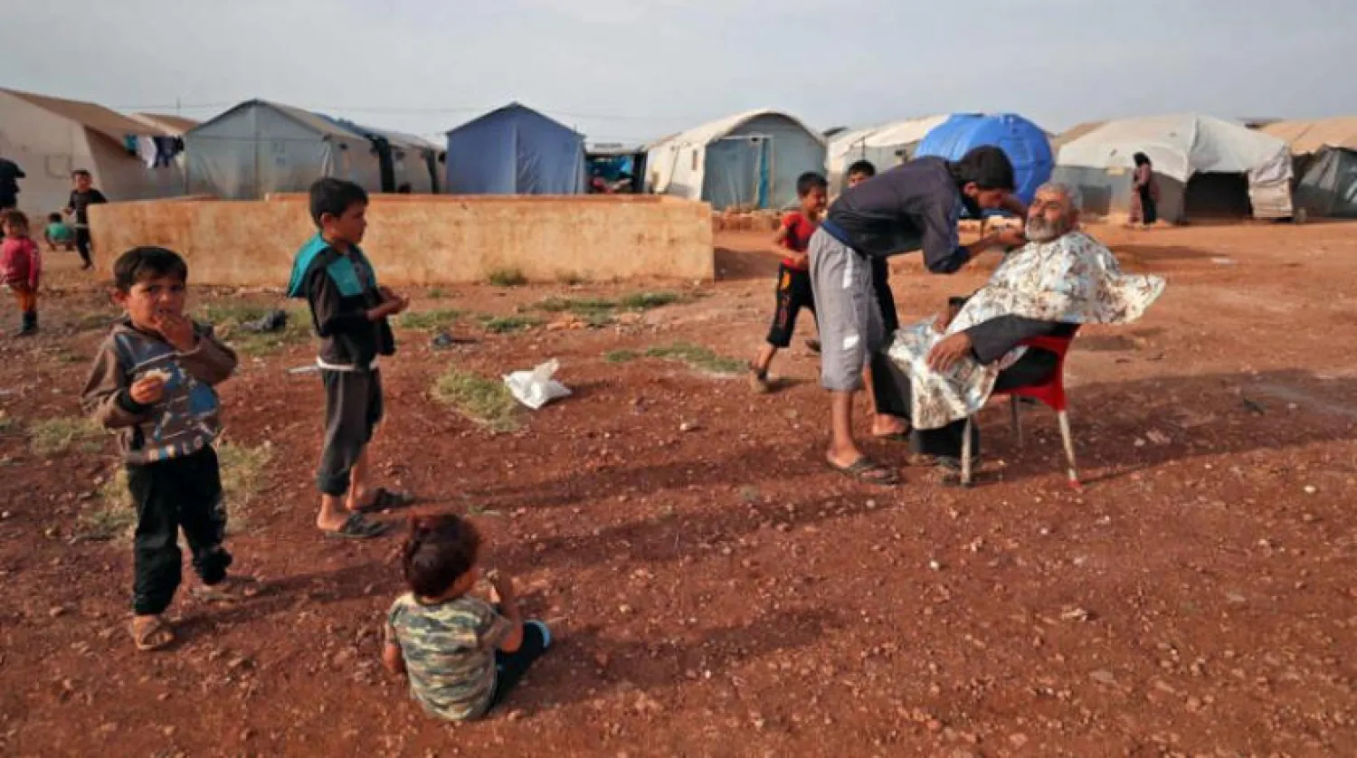 A Syrian man gets his beard trimmed in preparation for the upcoming Eid al-Fitr holiday which marks the end of the Muslim holy month of Ramadan, at a camp for the internally displaced in Maaret Misrin city in Syria's northwestern Idlib province on May 8, 2021. (Photo by OMAR HAJ KADOUR / AFP)