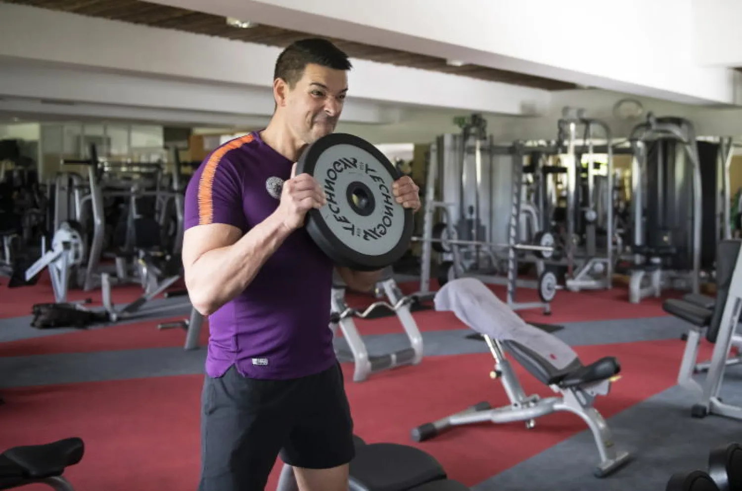 رجل يرفع الأثقال في صالة ألعاب رياضية بالمجر (إ.ب.أ)