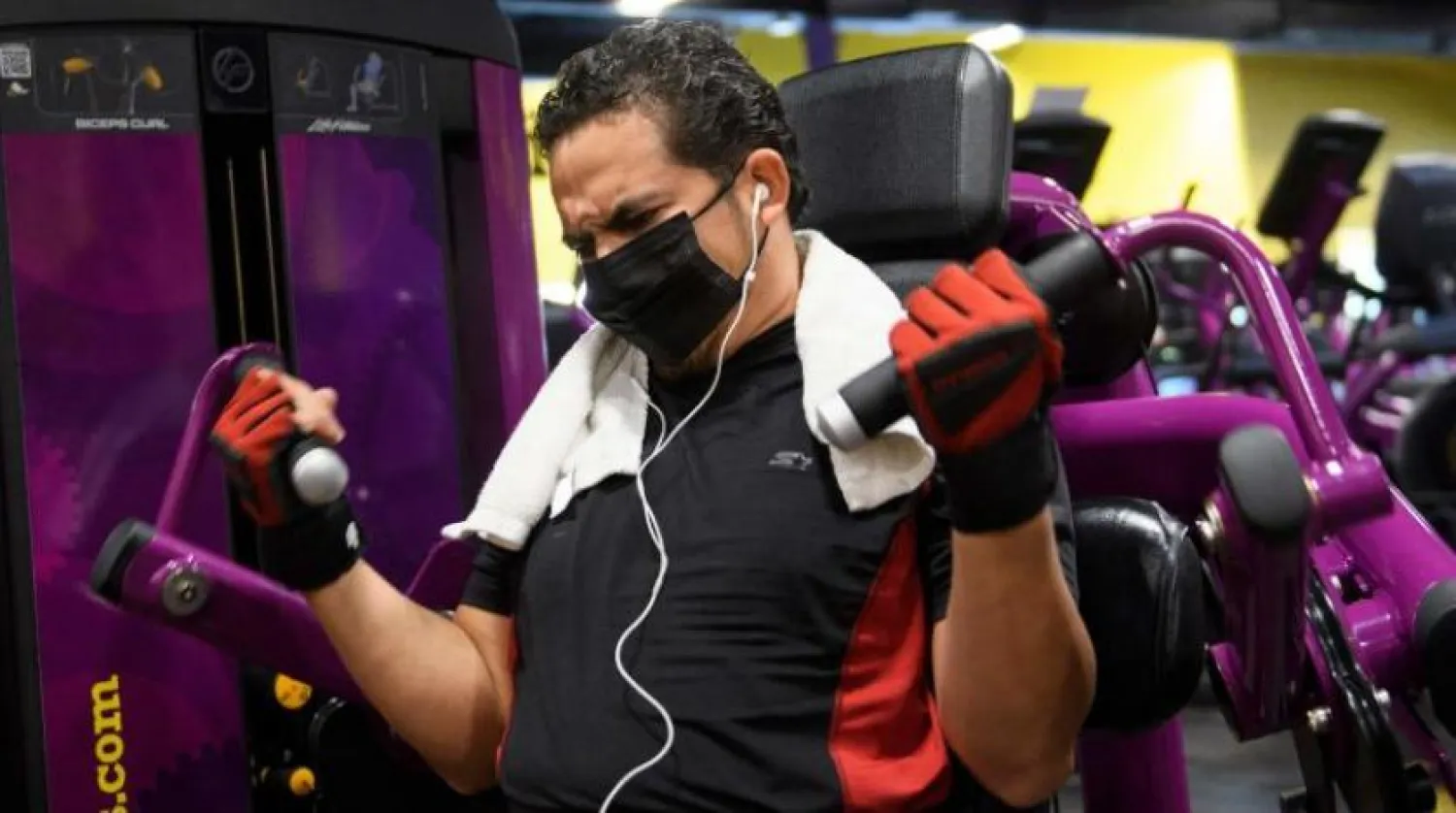 Bir adam Kaliforniya’da bir fitness salonunda spor yaptığı sırada maske takıyor. (AFP)