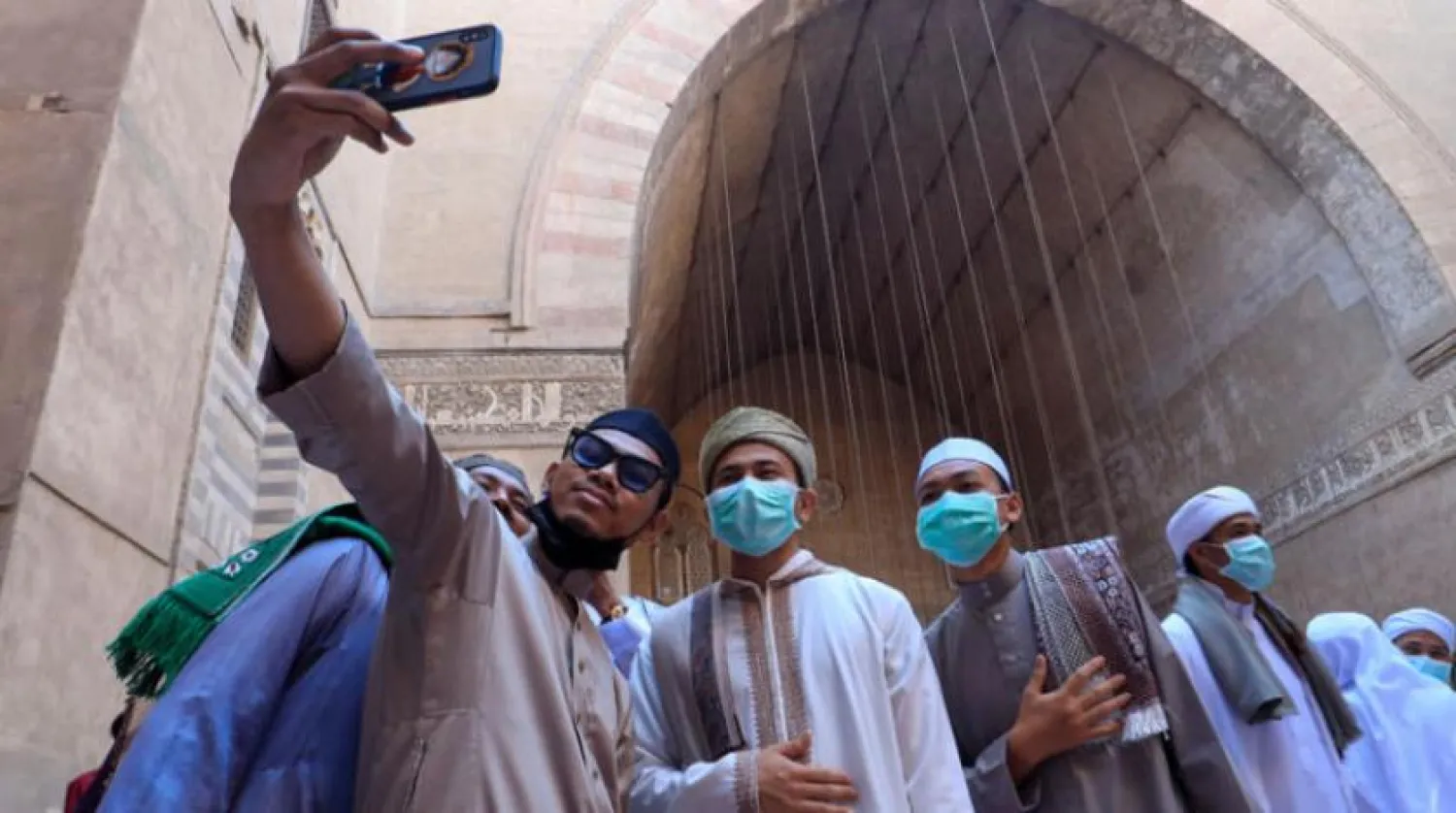 Worshippers take a selfie after Eid al-Fitr prayers marking the end of the Muslim holy fasting month of Ramadan, inside Al Sultan Hassan mosque, amid the coronavirus disease (COVID-19) pandemic, in old Cairo, Egypt May 13, 2021. REUTERS/Amr Abdallah Dalsh