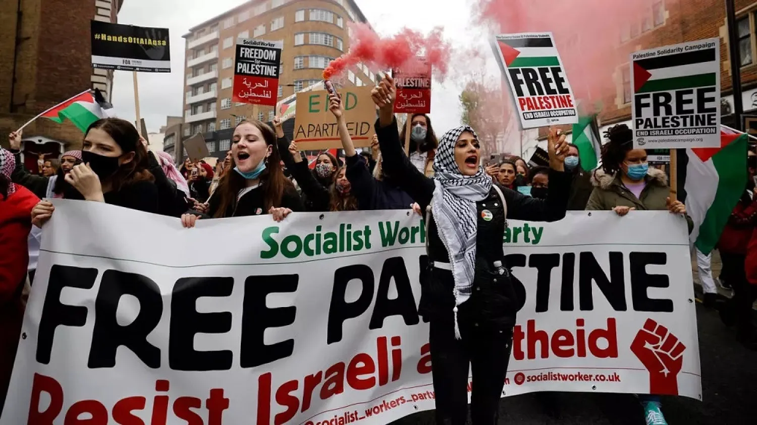 Pro-Palestinian activists and supporters let off smoke flares, wave flags and carry placards in central London. (AFP)