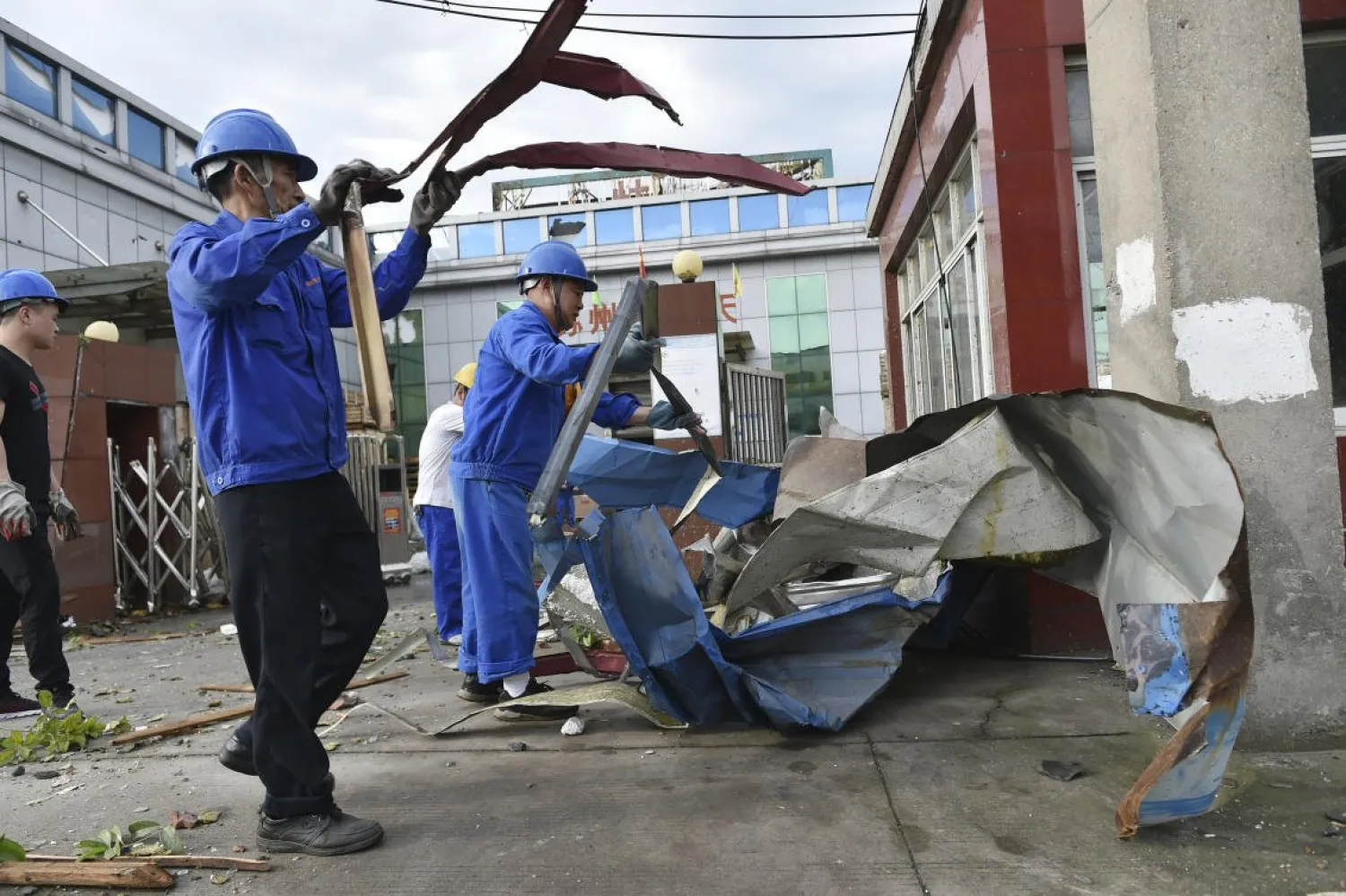 Workers clear debris at a factory that was damaged by a reported tornado in Shengze township in Suzhou in eastern China's Jiangsu Province on May 15, 2021. (Chinatopix via AP)