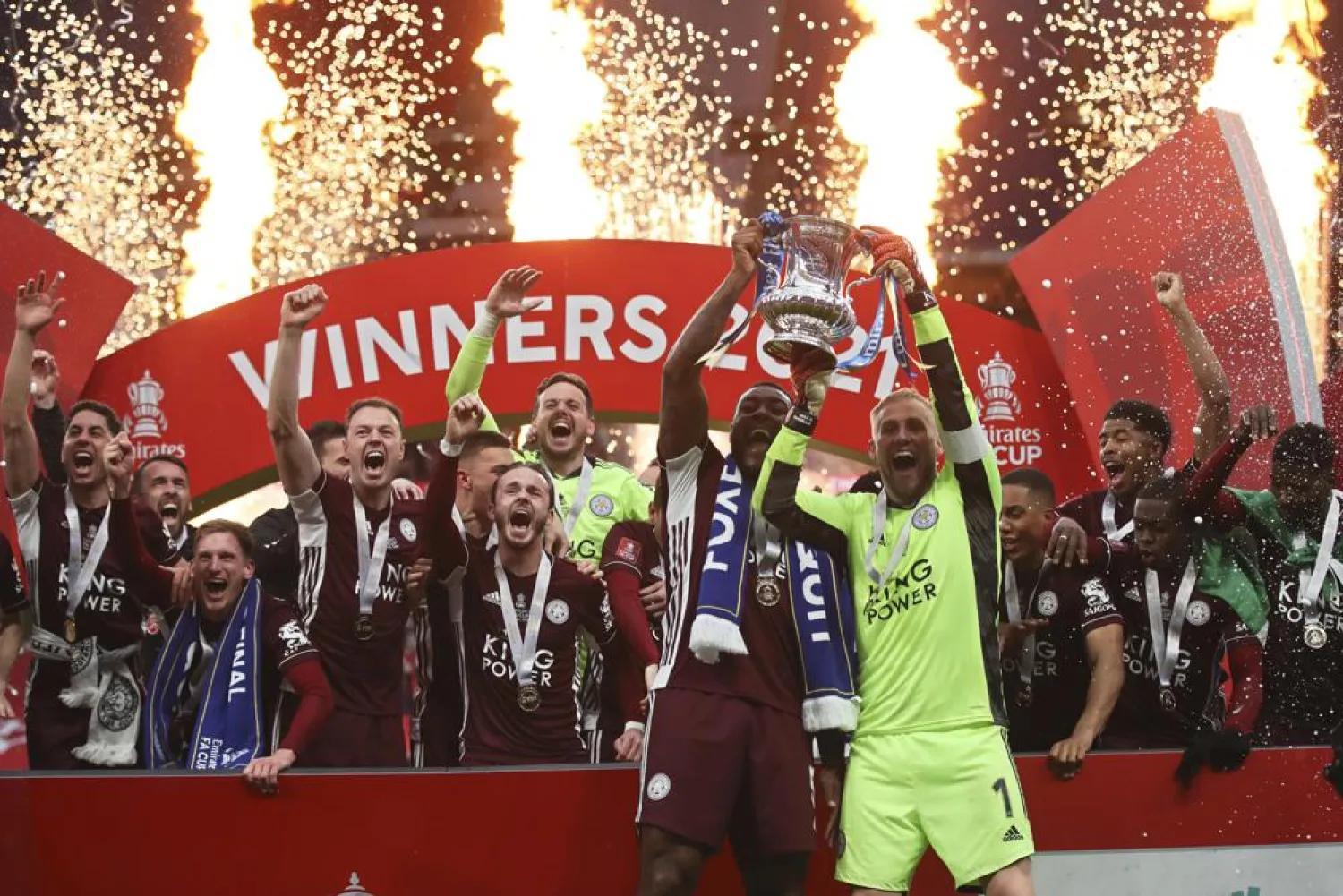 Leicester's goalkeeper Kasper Schmeichel, right, and Leicester's Wes Morgan lift the trophy after winning the FA Cup final against Chelsea at Wembley Stadium in London, England, May 15, 2021. (AP)