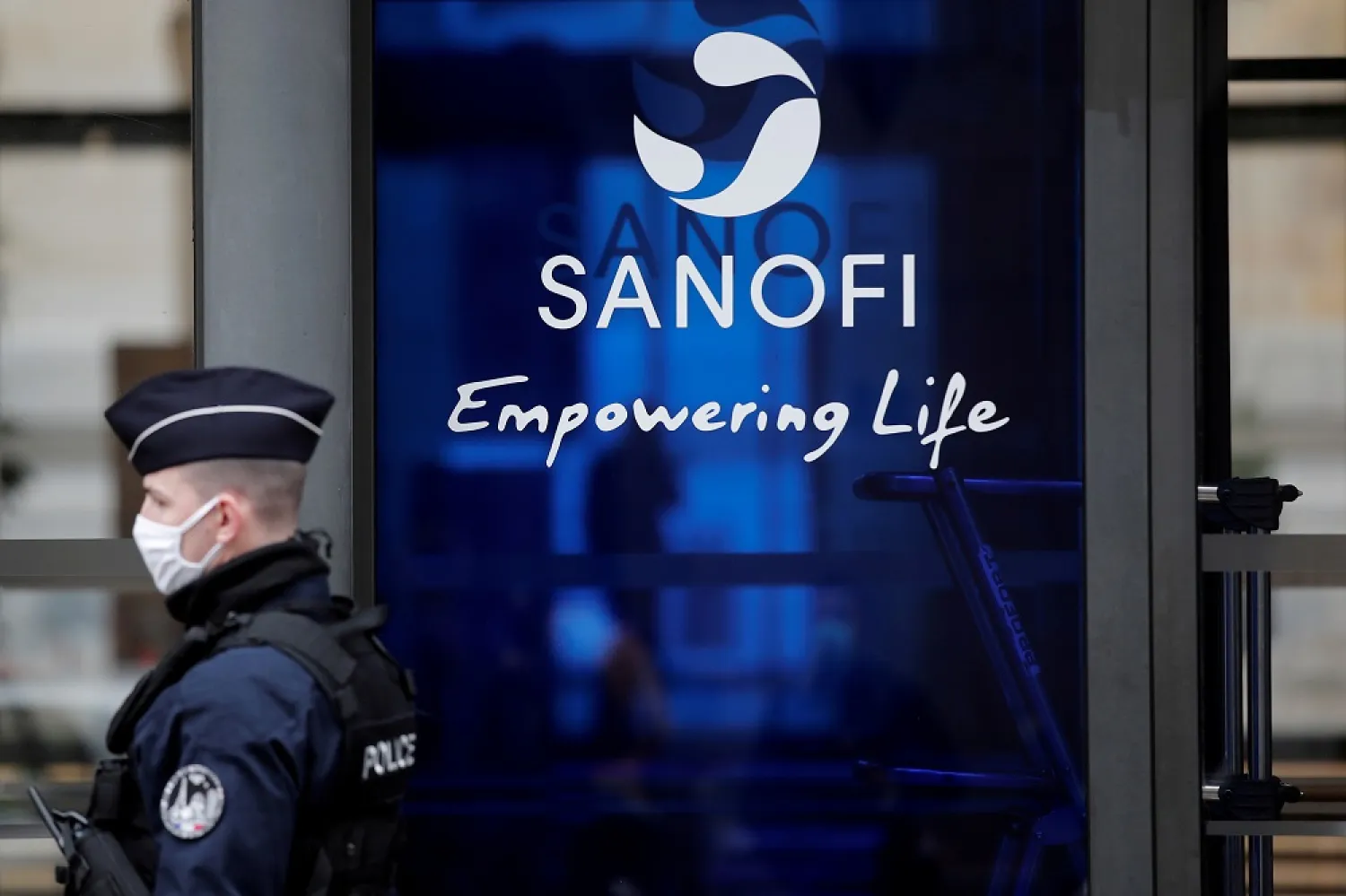 A French policeman stands in front of the Sanofi headquarters during a protest by Sanofi's workers against job cuts in Paris, France, February 4, 2021. (Reuters)