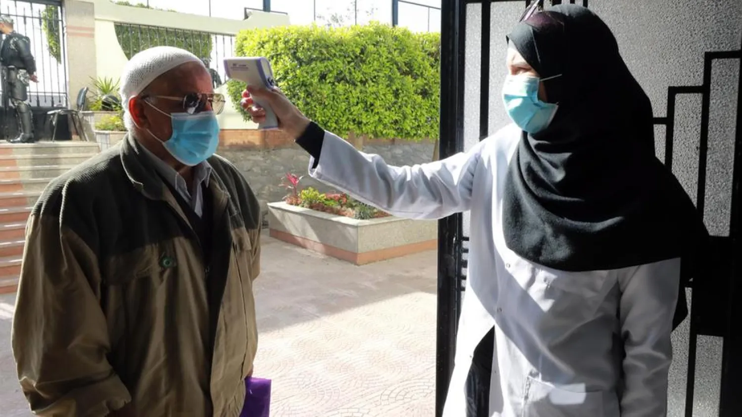 A health worker checks the temperature of an elderly man as he arrives at a vaccination center to receive a COVID-19 vaccine in Cairo, Egypt. (EPA)