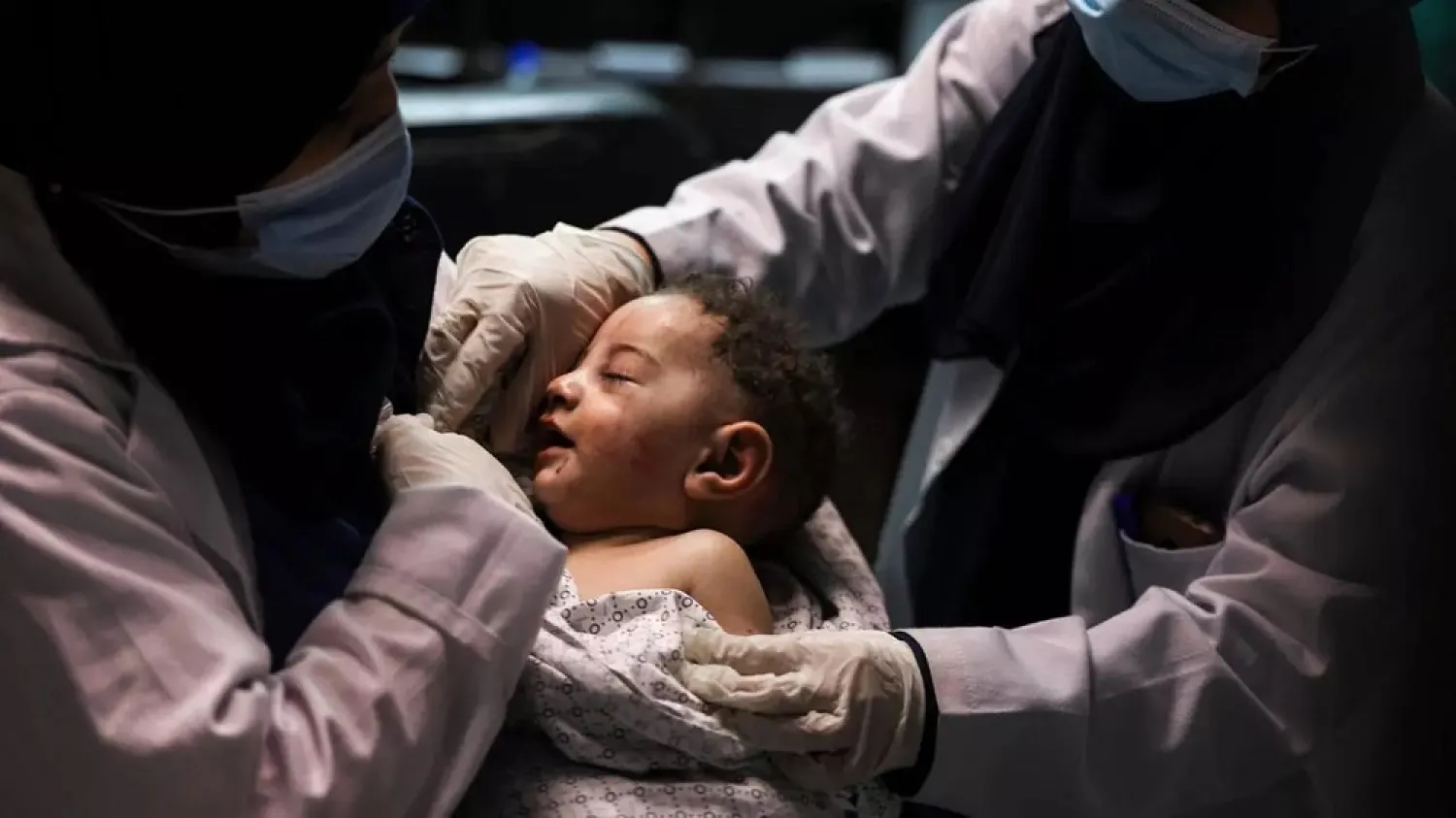 A nurse holds five-month-old Omar al-Hadidi who was pulled alive from under the rubble of a home hit by an Israeli air strike in Gaza while his mother and four siblings were killed. (AFP)