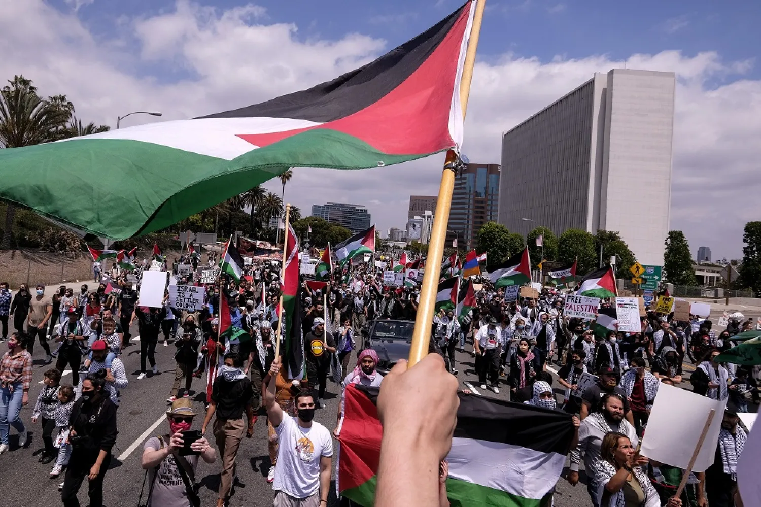 Demonstrators holding signs march to Israeli Consulate during a protest against Israel and in support of Palestinians, in Los Angeles, US, May 15, 2021. (AP)