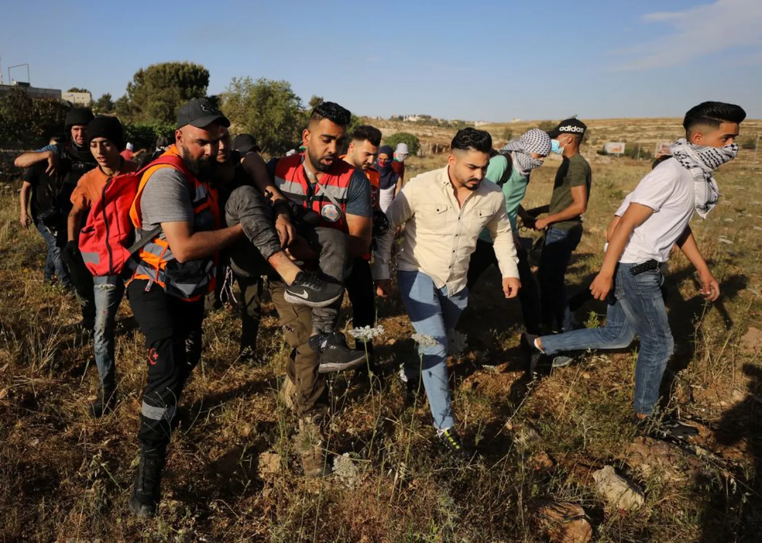 Palestinians carry an injured during a protest over tension in Jerusalem and Israel-Gaza escalation, near Ramallah in the Israeli-occupied West Bank, May 16, 2021. REUTERS/Ammar Awad



