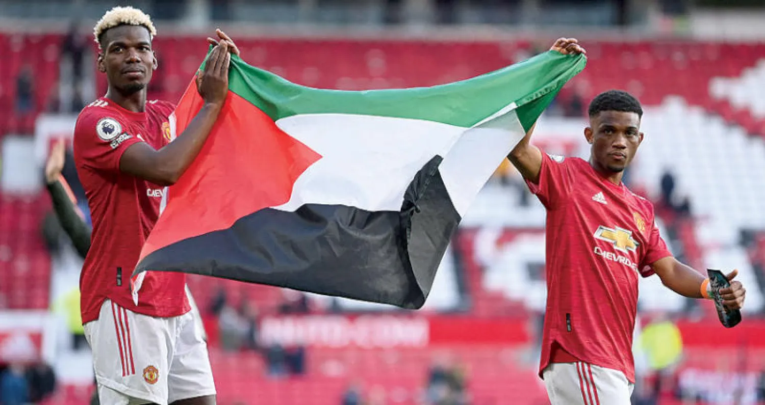 بوغبا وديالو يطوفان حول ملعب «أولد ترافورد» بعلم فلسطين بعد مباراة يونايتد وفولهام (أ.ف.ب)