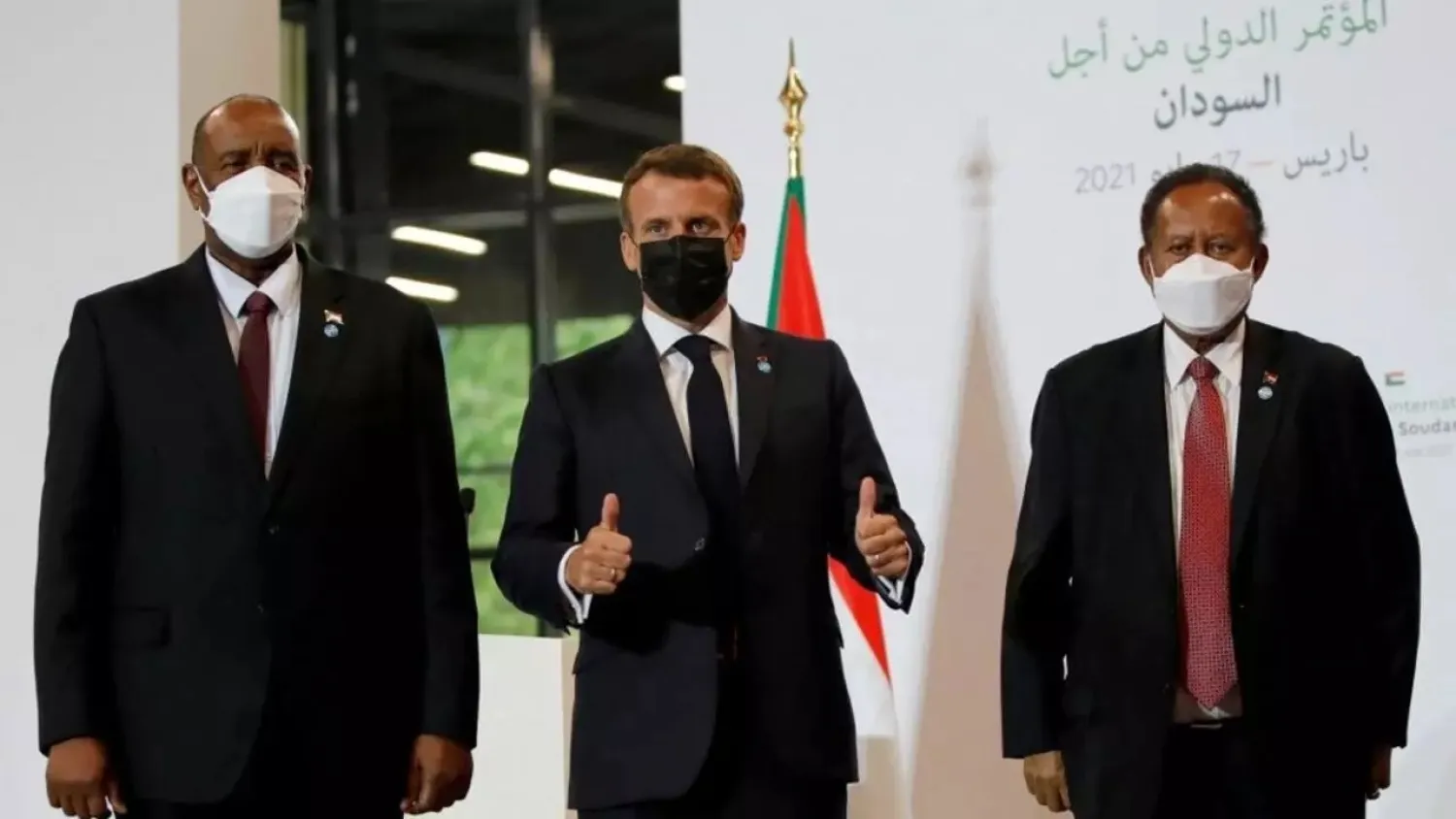 French President Emmanuel Macron (C), Sudanese Prime Minister Abdalla Hamdok (R) and Sudan Sovereignty Council Chairman Abdel Fattah al-Burhan in Paris on Monday. (AFP)