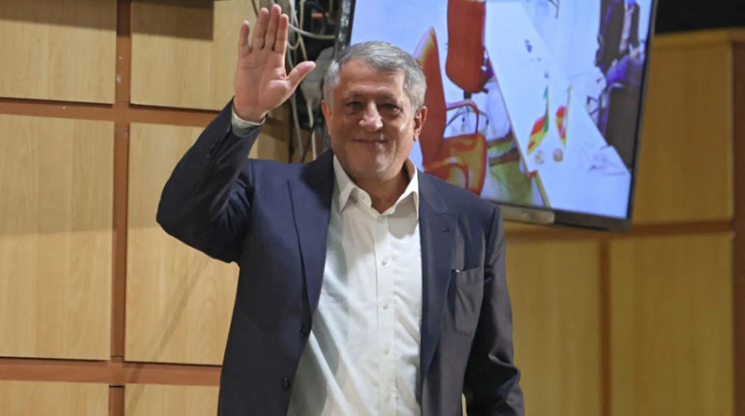 رئيس مجلس بلدية طهران محسن هاشمي نجل الرئيس السابق علي أكبر هاشمي رفسنجاني يرفع يده لوسائل الإعلام بعد تقديمه طلب الترشح السبت الماضي (أ.ف.ب)