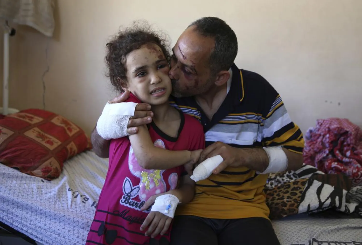 Suzy Ishkontana, 7, is kissed by her father Riad Ishkontana, 42, at Shifa Hospital in Gaza City, Tuesday, May 18, 2021. (AP)