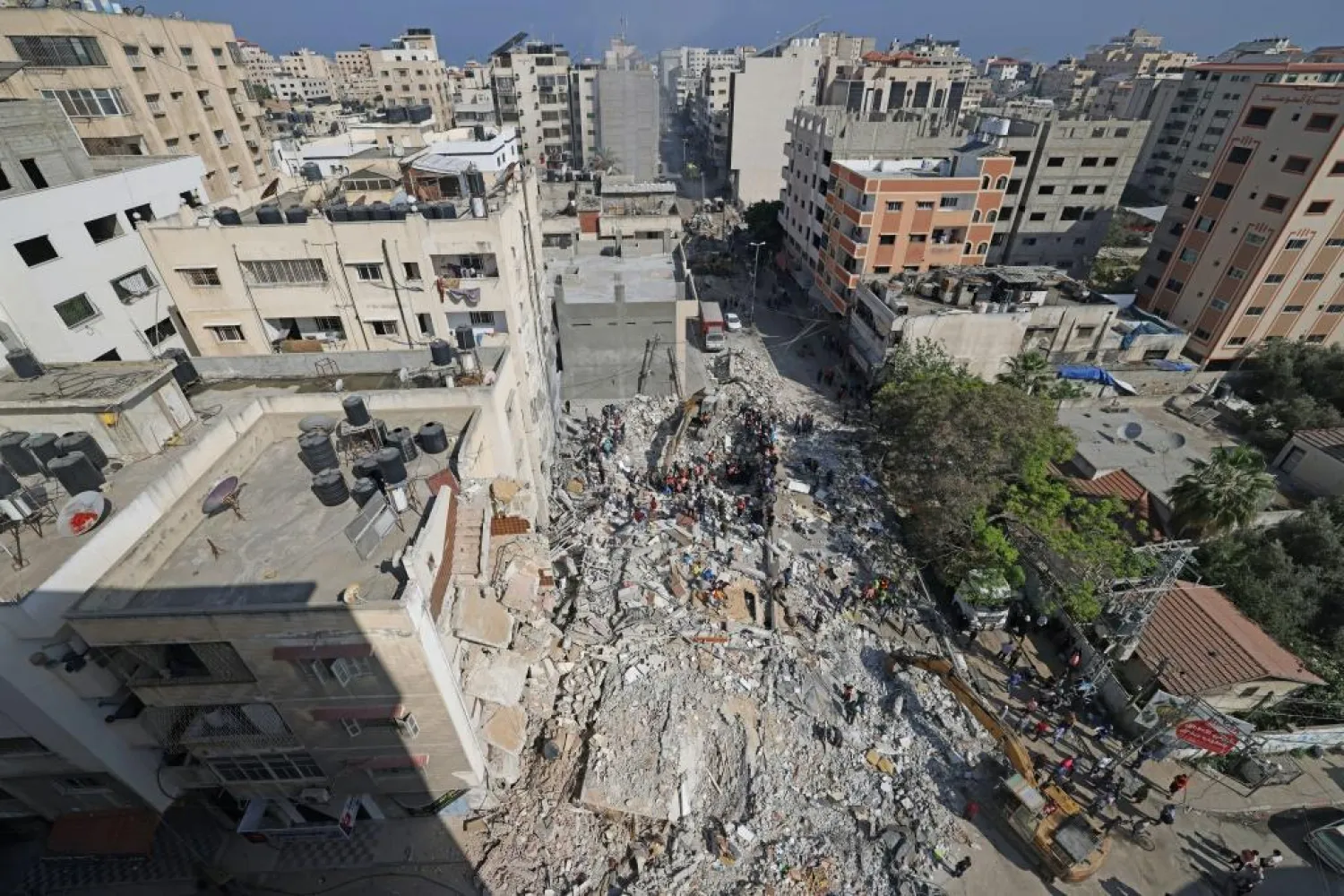 Palestinian rescue teams search for survivors under the rubble of a destroyed building in Gaza City's Rimal residential district on May 16 - AFP