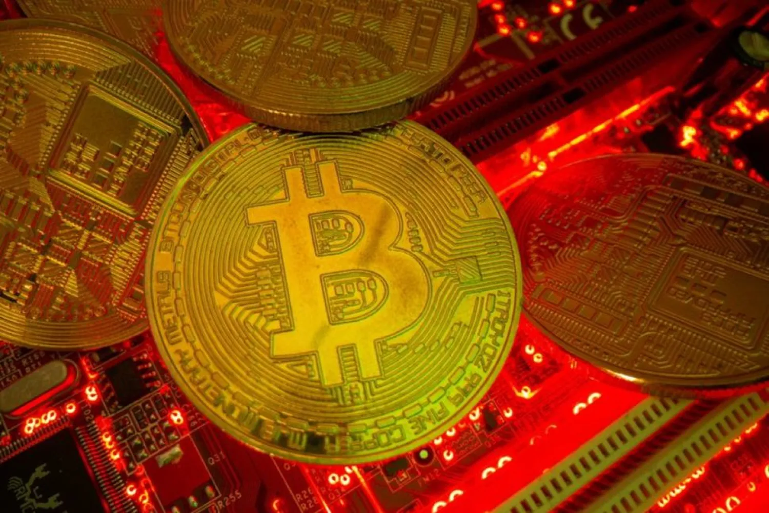 Representations of the virtual currency Bitcoin stand on a motherboard in this picture illustration taken May 20, 2021. (Reuters)