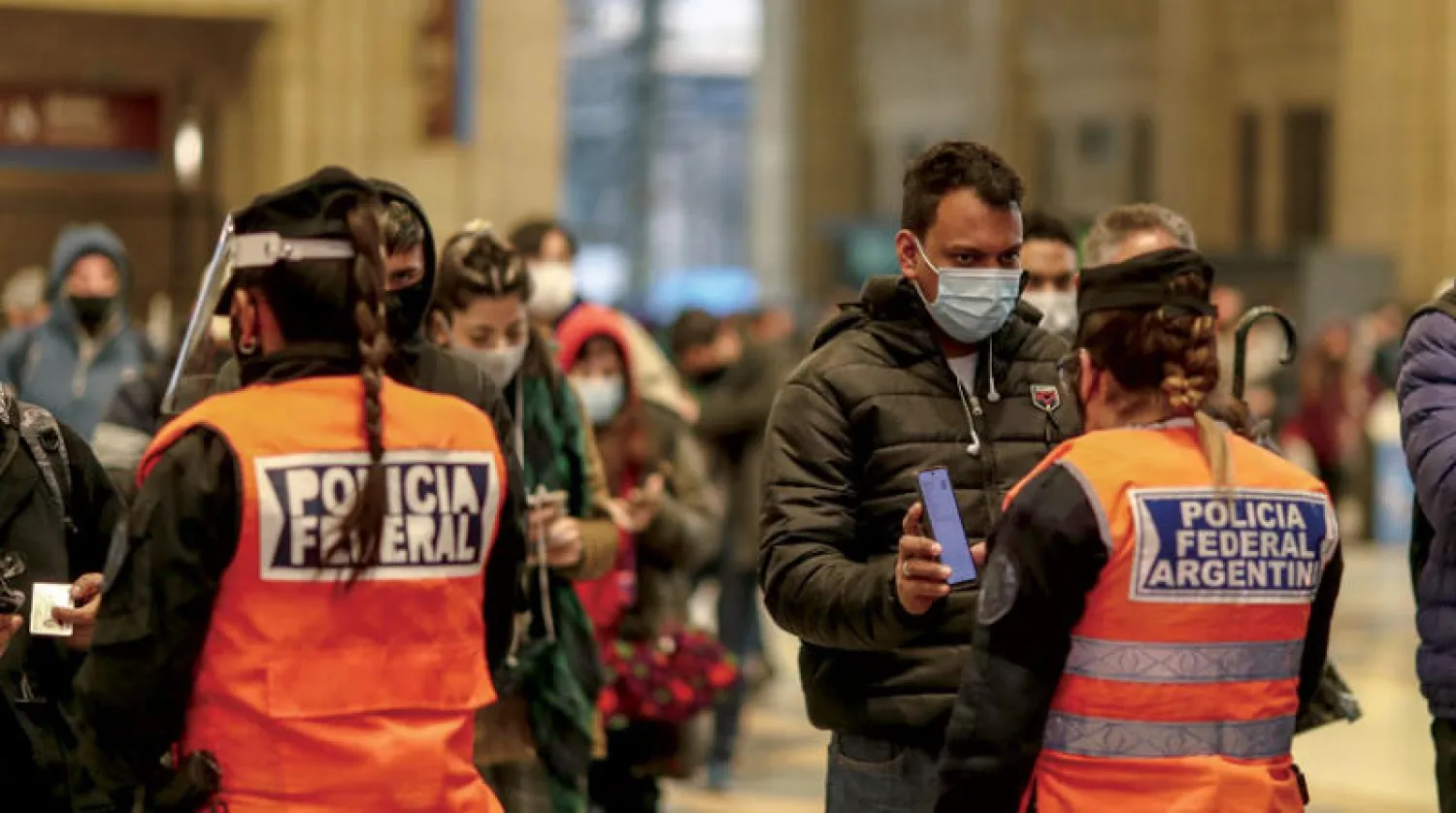 أفراد من الشرطة يراقبون حركة الأشخاص خلال اليوم الأول من الإجراءات الصارمة في بوينس آيرس بالأرجنتين للحد من انتشار فيروس {كورونا} (إ.ب.أ)