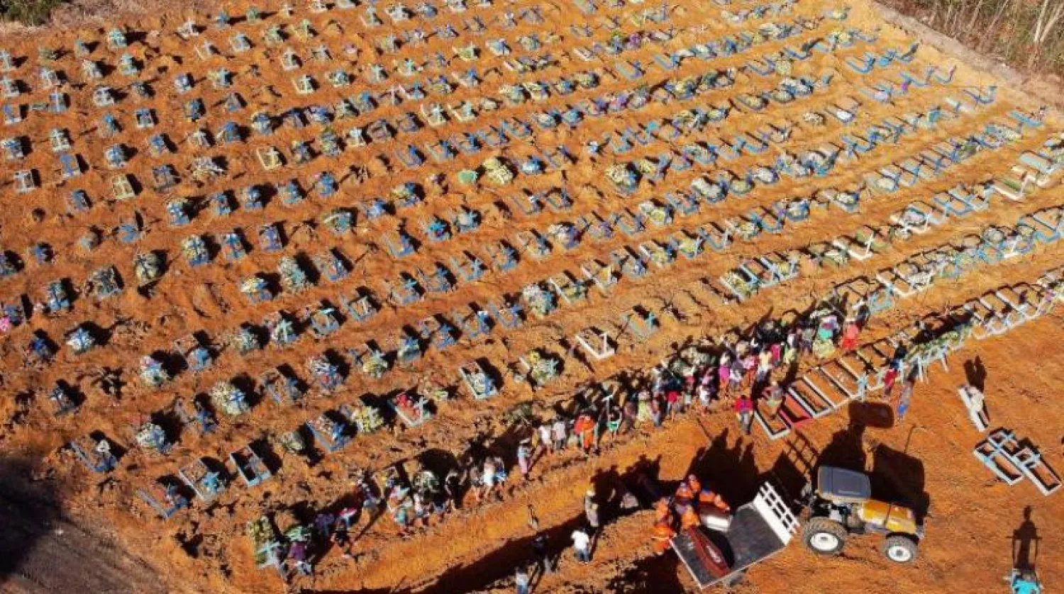 Brezilya eyaleti Amazon'daki Manaus kentinde koronavirüs nedeniyle hayatını kaybeden bir kişi mezarlık çalışanları tarafından defnediliyor (AFP)