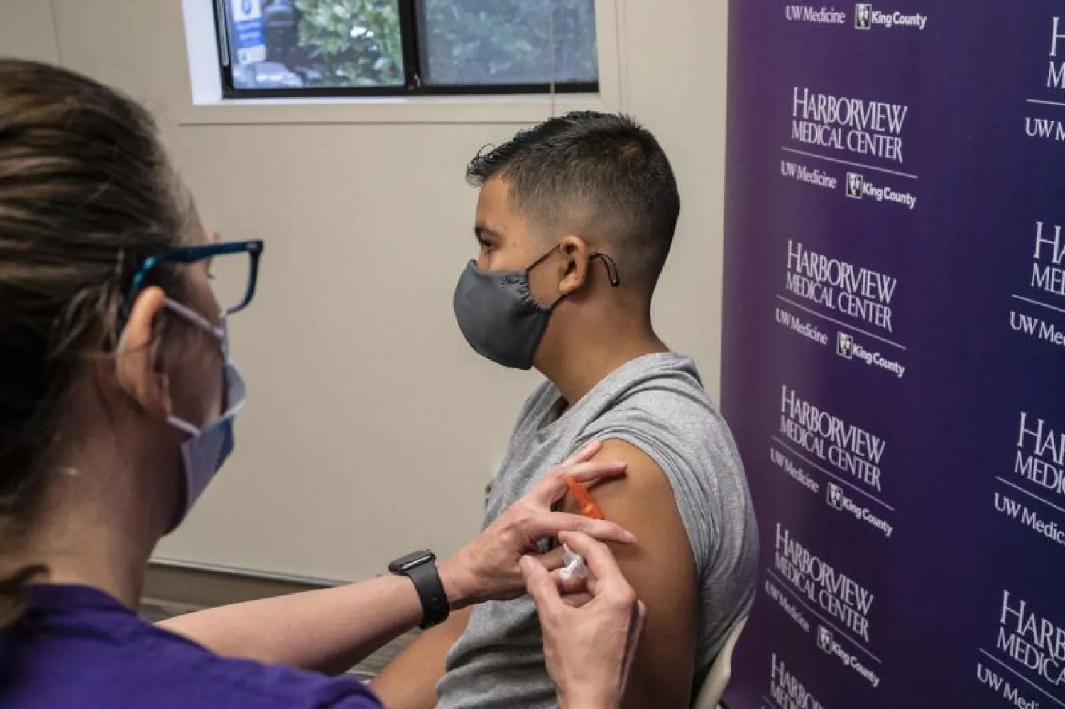 شاب يحصل على لقاح «فايزر - بيونتيك» في مدينة سياتل الأميركية (أ.ف.ب)