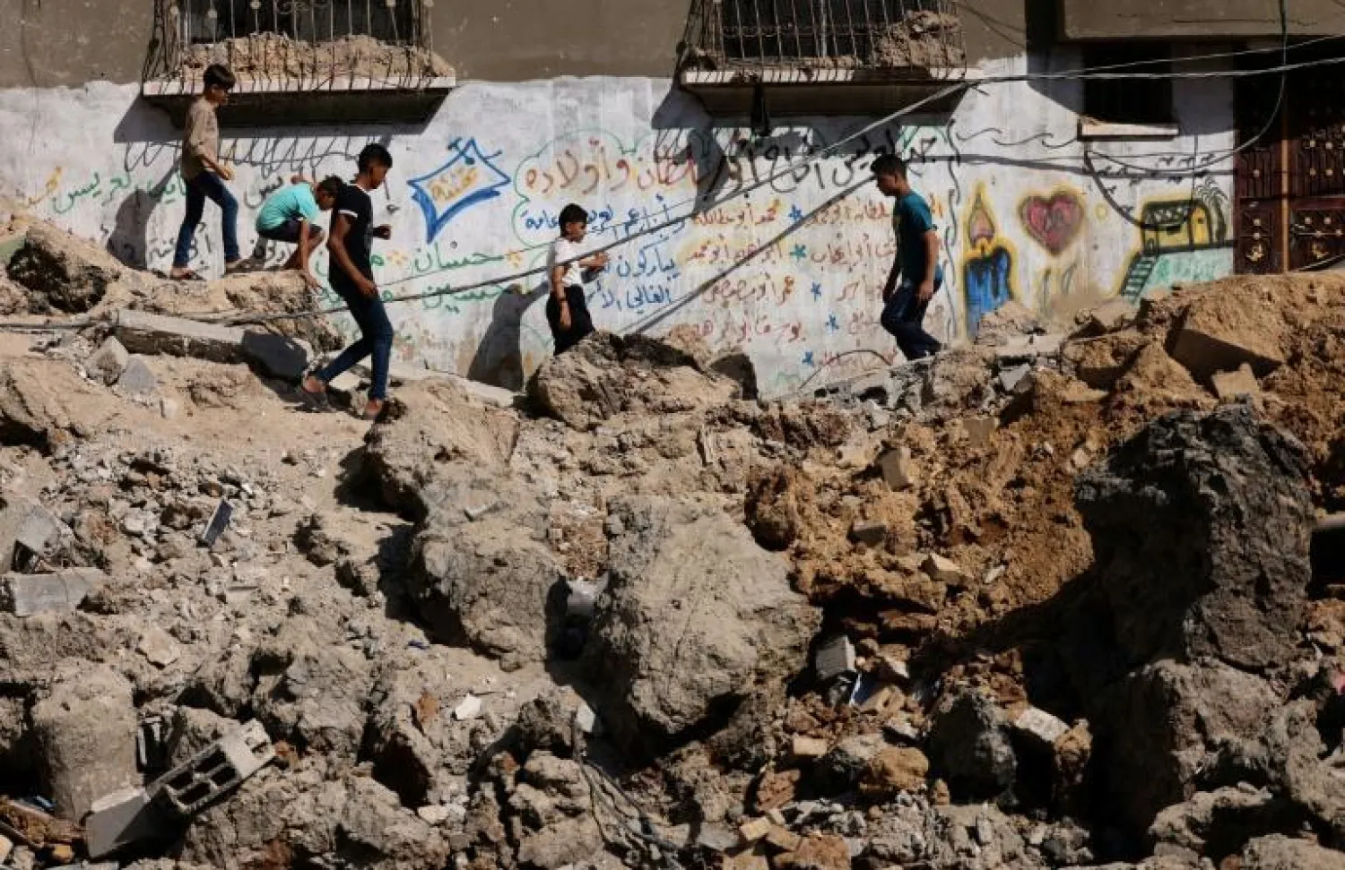 Palestinian children walk amid the rubble of buildings destroyed by Israeli strikes in Beit Hanun in the northern Gaza Strip on May 21 - AFP