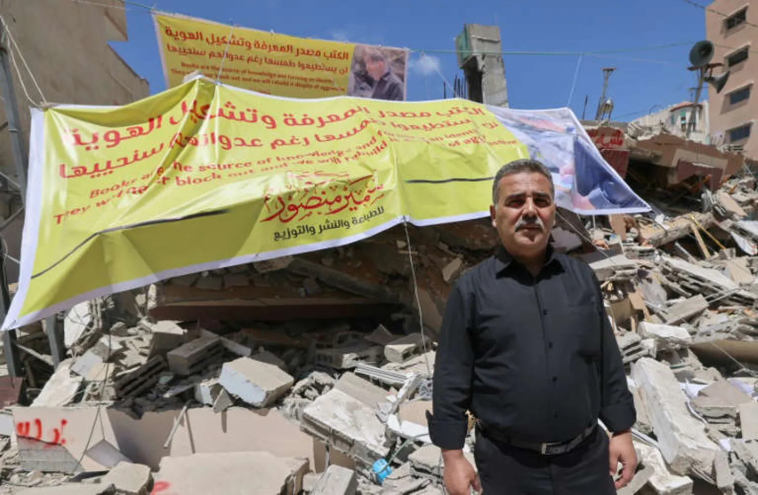 Samir al-Mansour stands in front of the rubble of his bookshop in Gaza City. 'Forty years of my life were obliterated in less than a second,' he said - AFP
